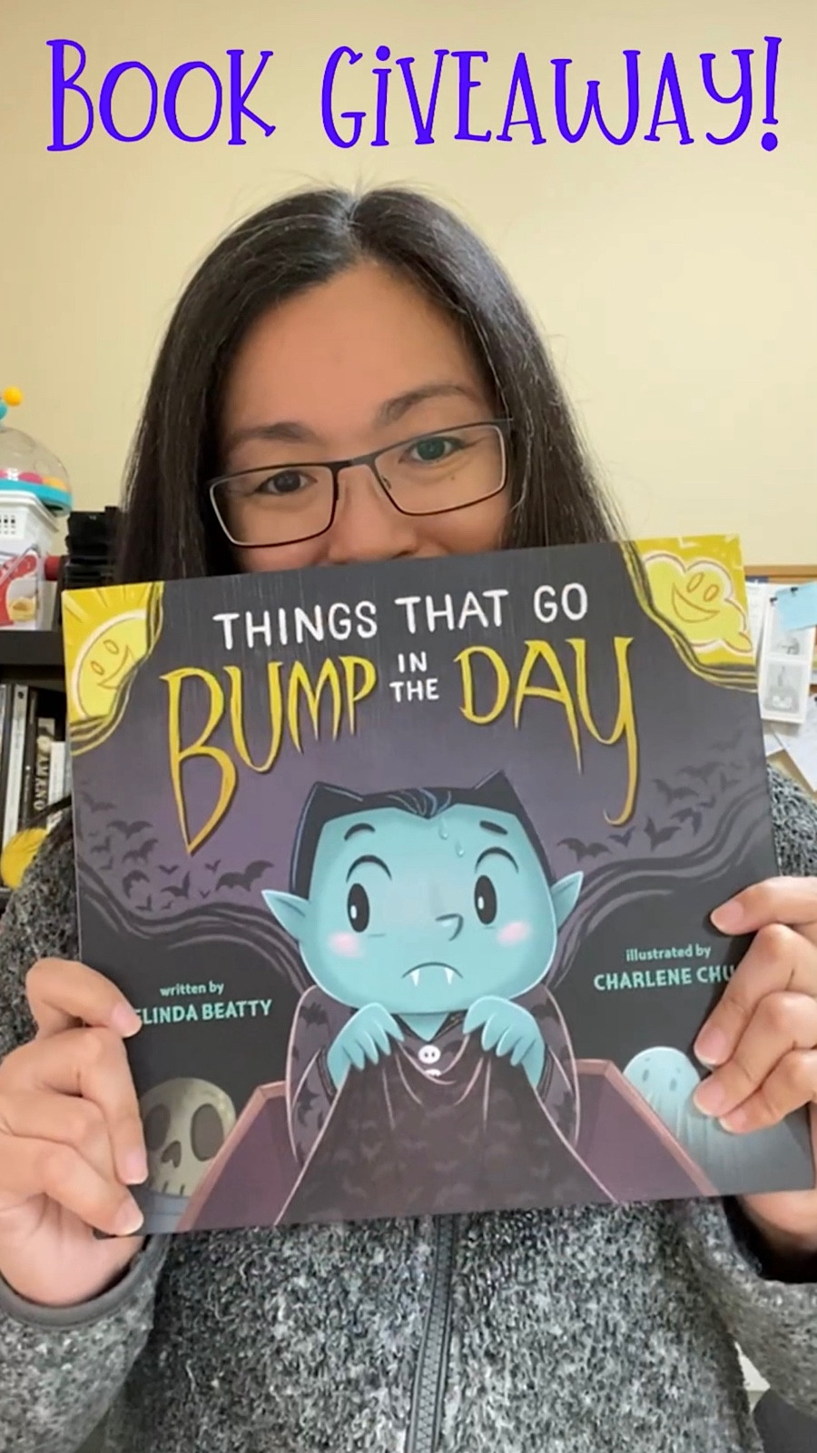 Photo of person holding up a copy of Things That Go Bump in the Day by Melinda Beatty and illustrated by Charlene Chua. Words above say Book Giveaway