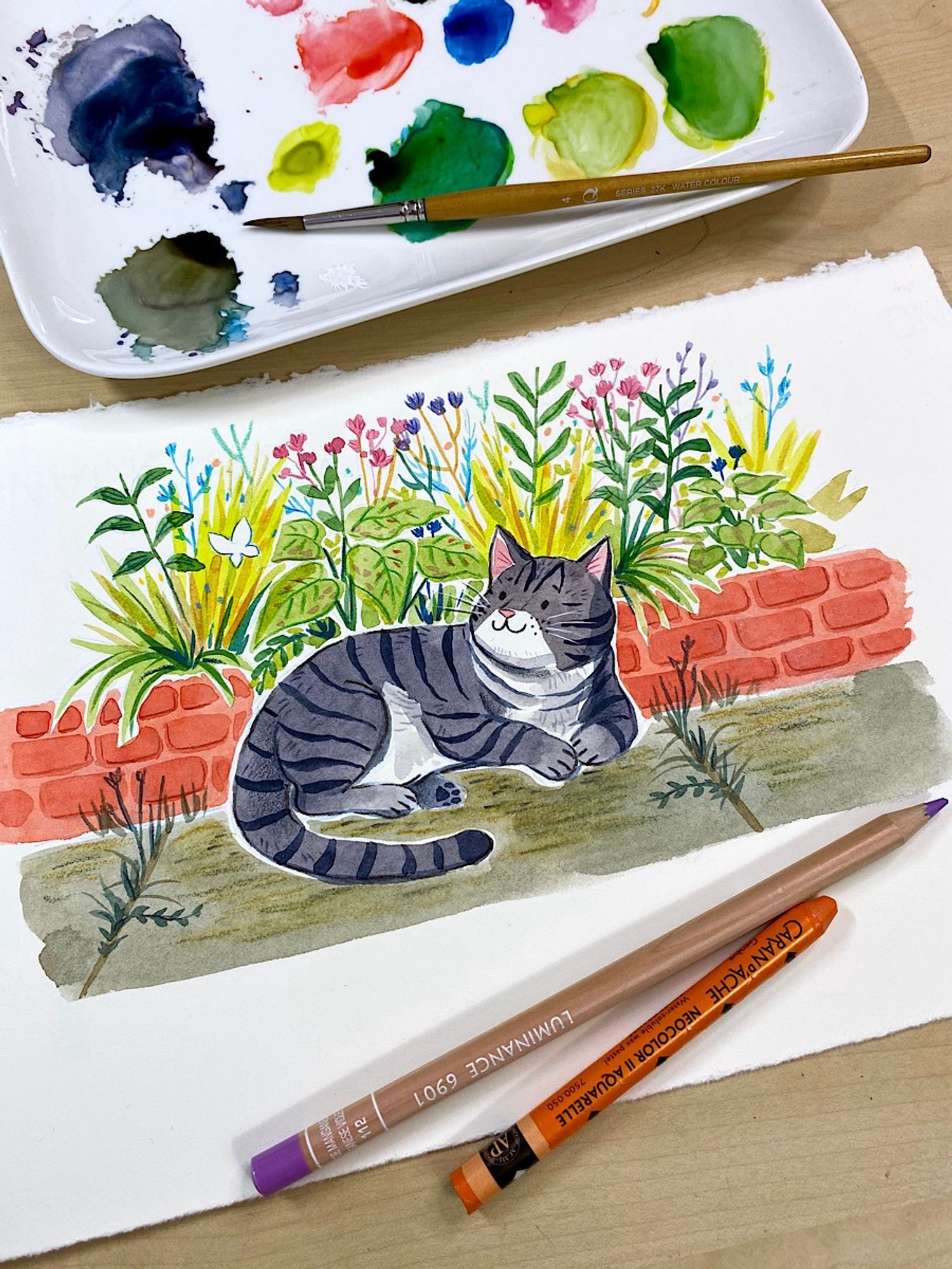 Painting of a grey striped cat in a garden, looking at a white butterfly