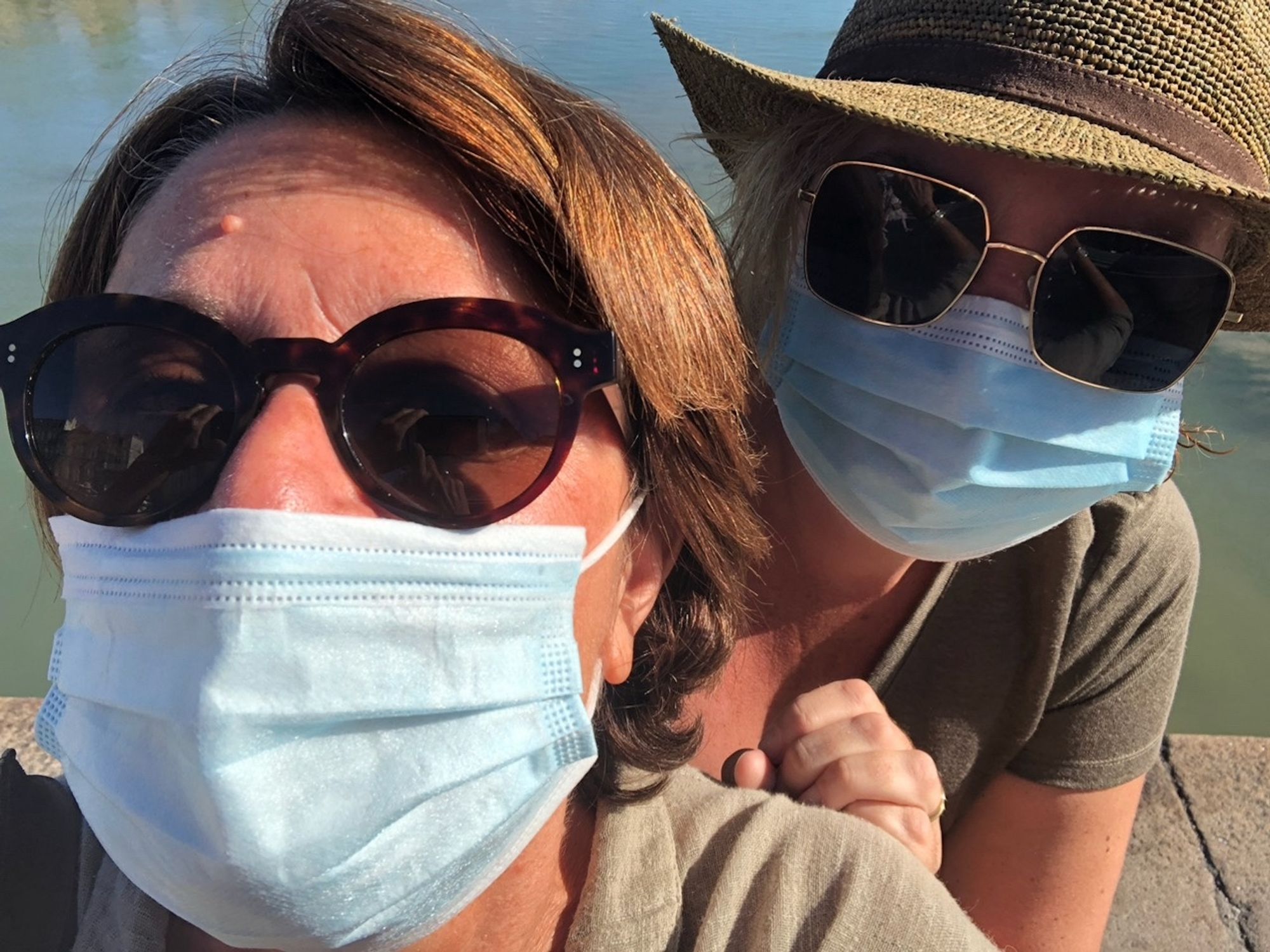 2 femmes avec masques chirurgicaux et lunettes de soleil