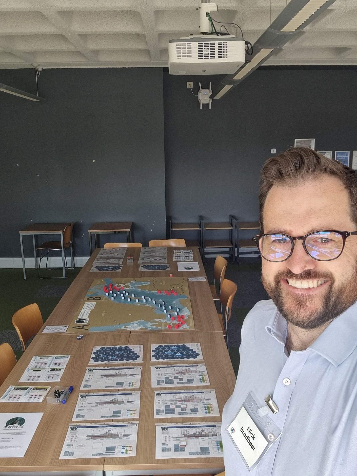 Selfie of the author in front of a long table set up for a game of A Balanced Fleet.