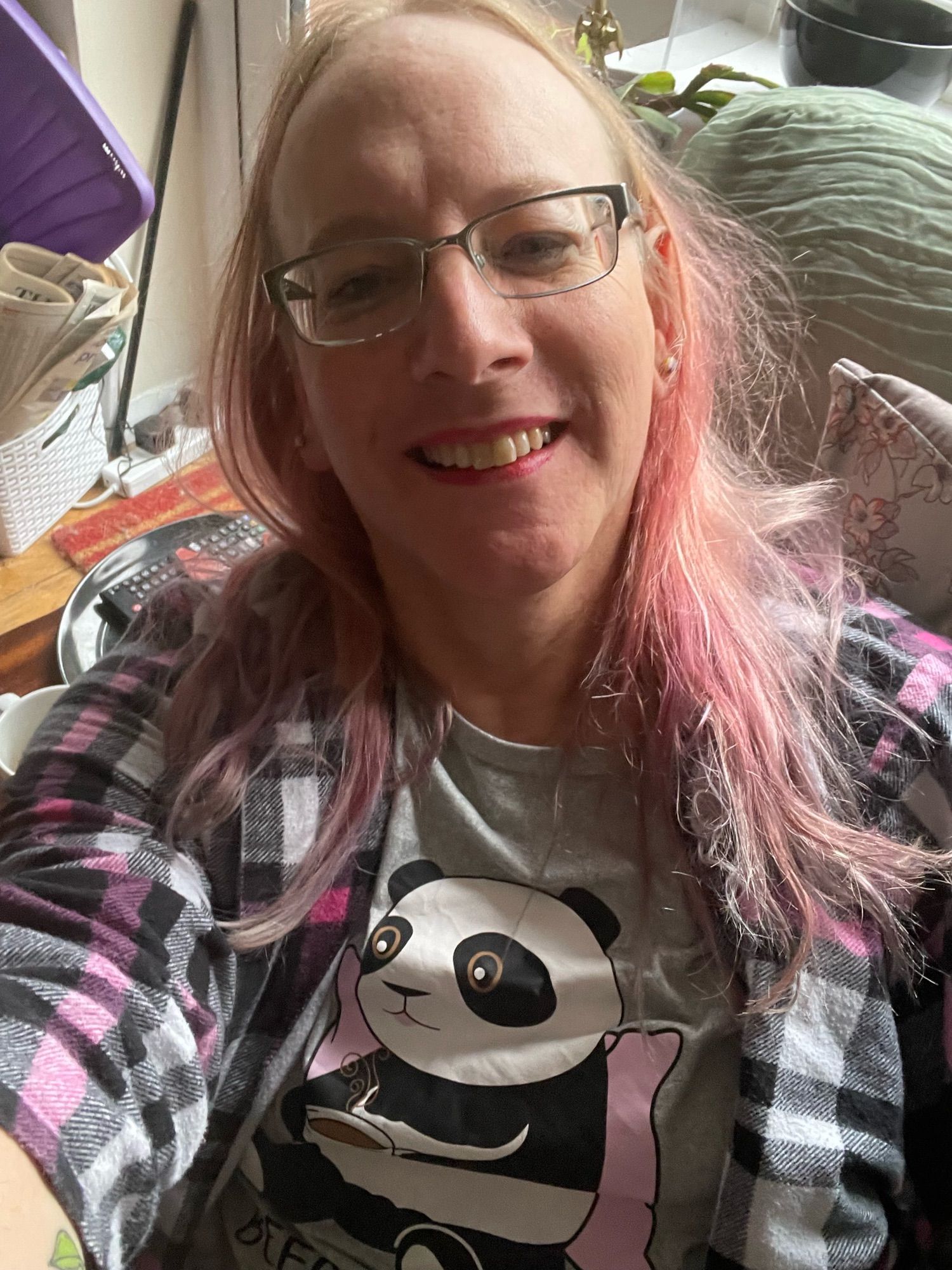 A selfie of me in the sofa looking sleep-tousled. I’m wearing panda pyjamas and an otherwise pink plaid shirt.