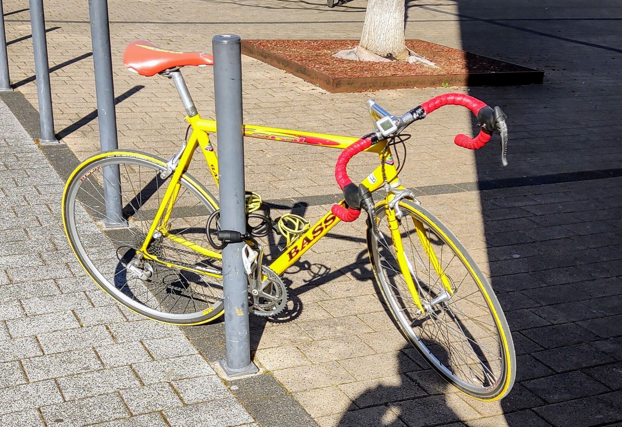 Rennrad angeschlossen an einem oben offenen Pfosten.