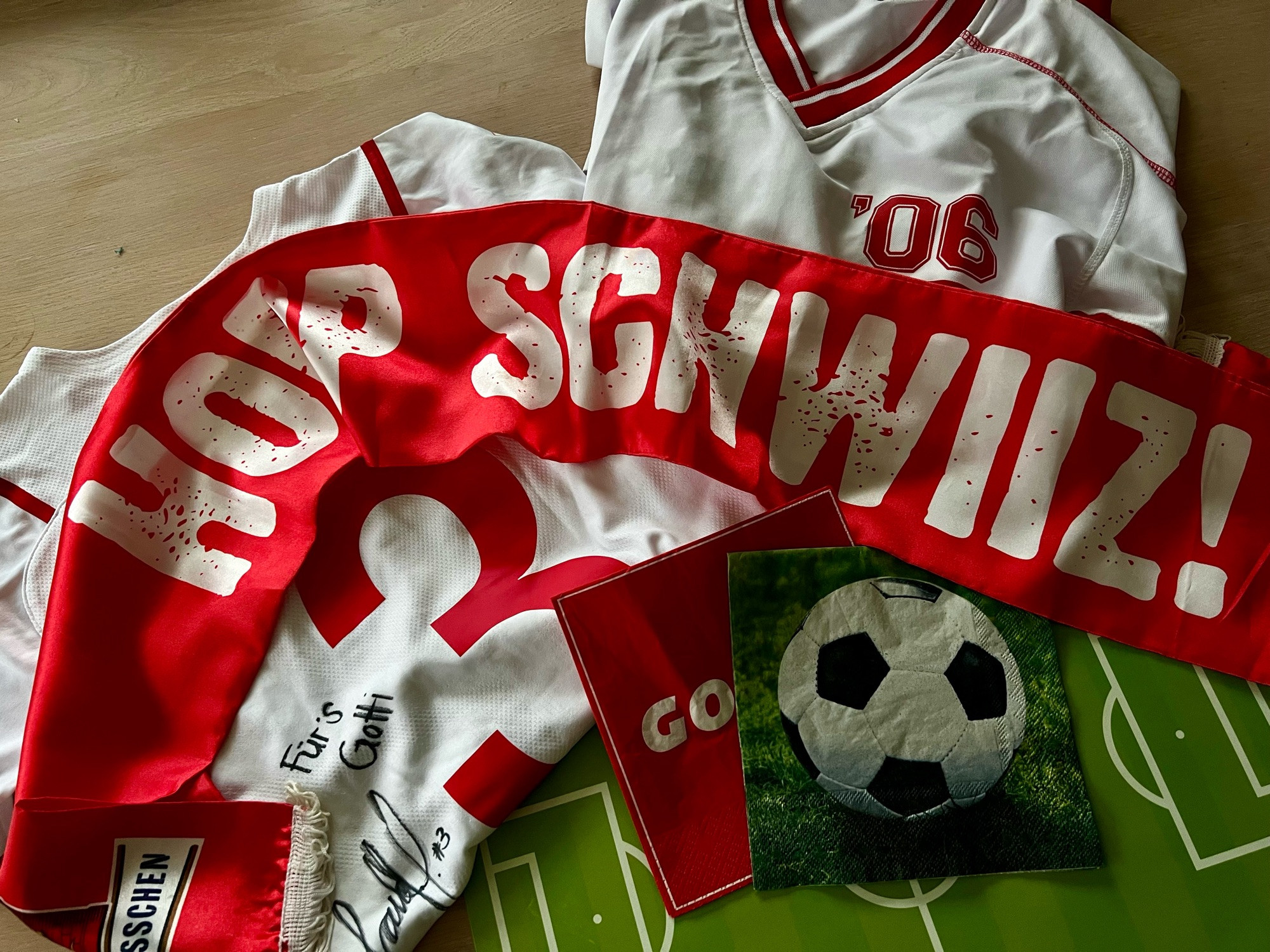 1 Original Schweizerinnen Nationaltrikot, 1 Schal mit „Hopp Schwiiz!“, ein Fussball-Shirt von 2006, Serviette mit Fussball, Serviette mit GOAL, Tischset mit Fussball-Feld