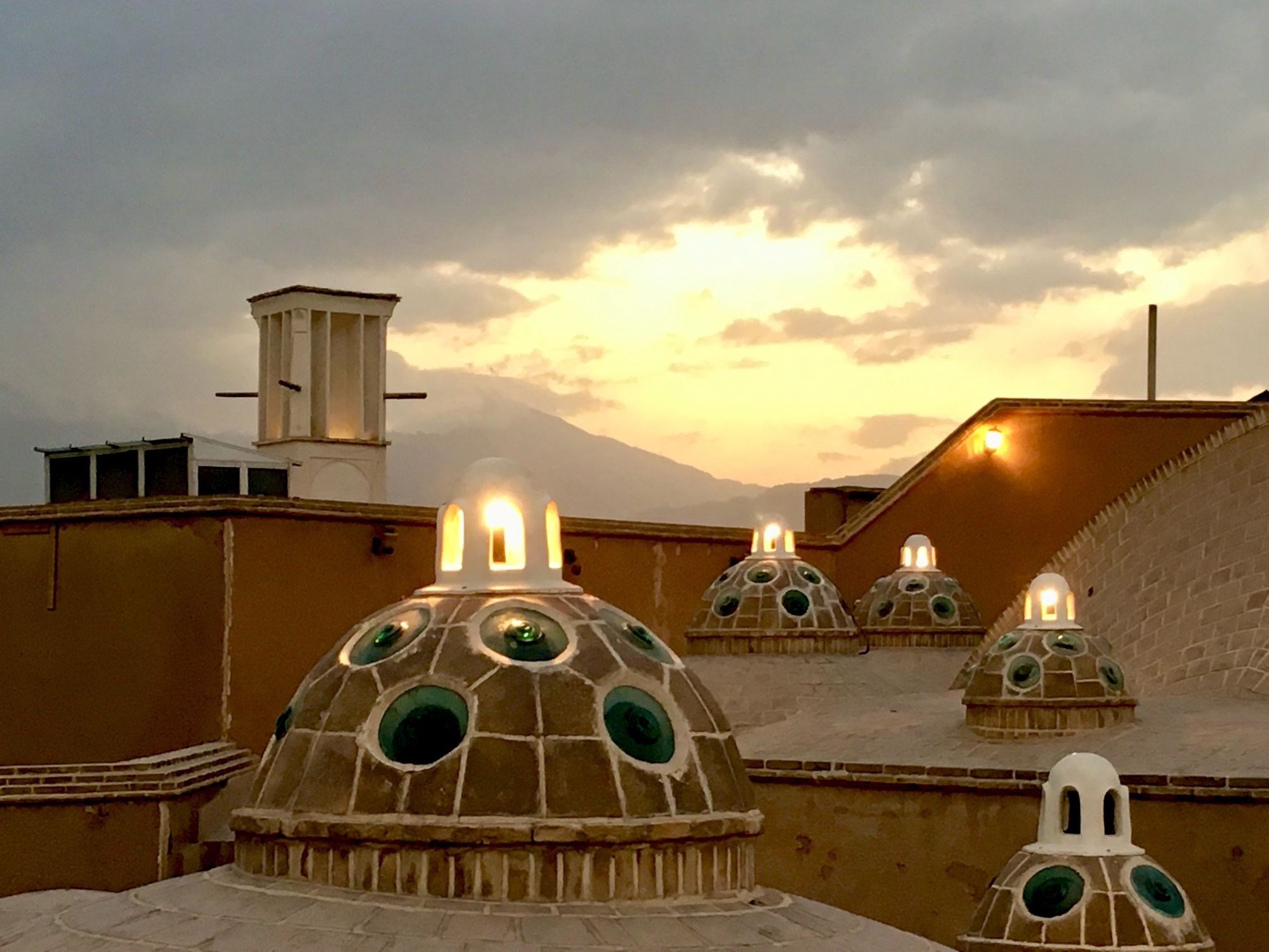 On top of historic Hammam with cupolas ; wind tower; sun setting