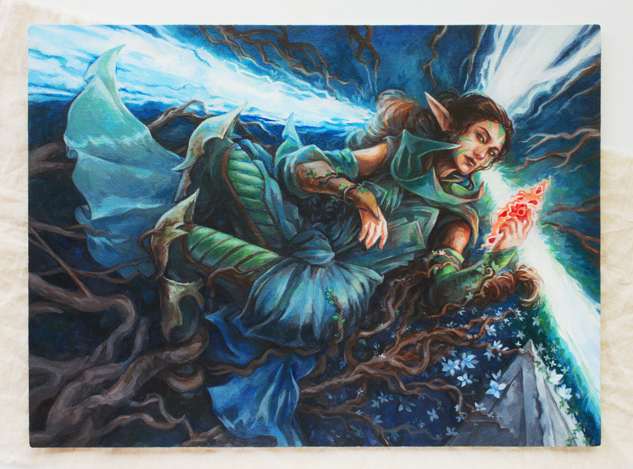 Fanart of Nissa from Magic the Gathering. Nissa is an elf with long brown hair, tied back, and wearing green clothing and armor. She's lying on a forest floor, overgrown with tree roots and delicate white flowers. Her head lies at the intersection of three magical leylines, each with subtle colors hinting at the blue, green, and black mana used in the card game for Nissa's cards. She's summoning fire magic shaped like a lotus flower in her left hand, looking pensively at it...