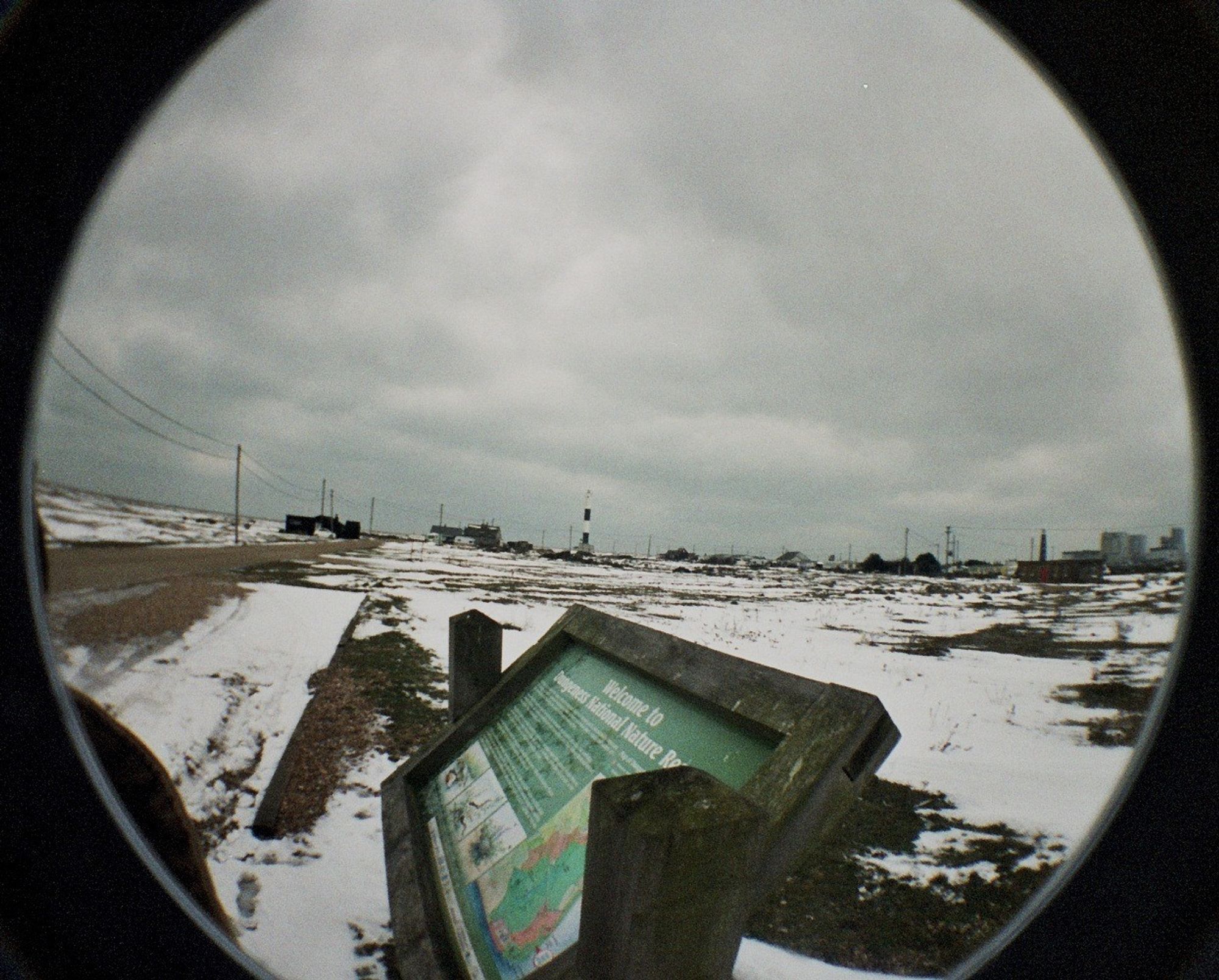 A fisheye view of Dungeness, with a sign in the foreground