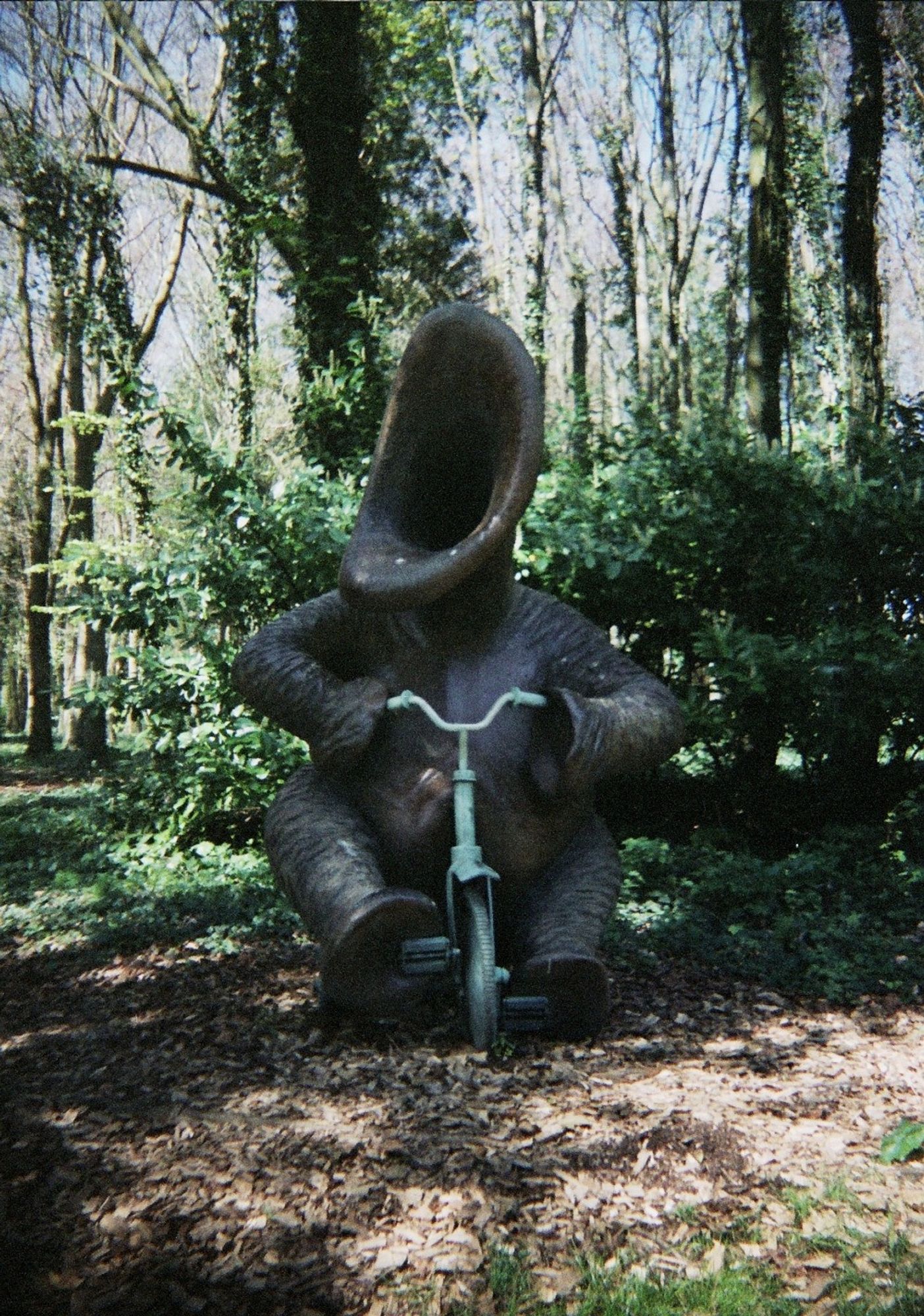 a sculpture of a strange creature riding a trike