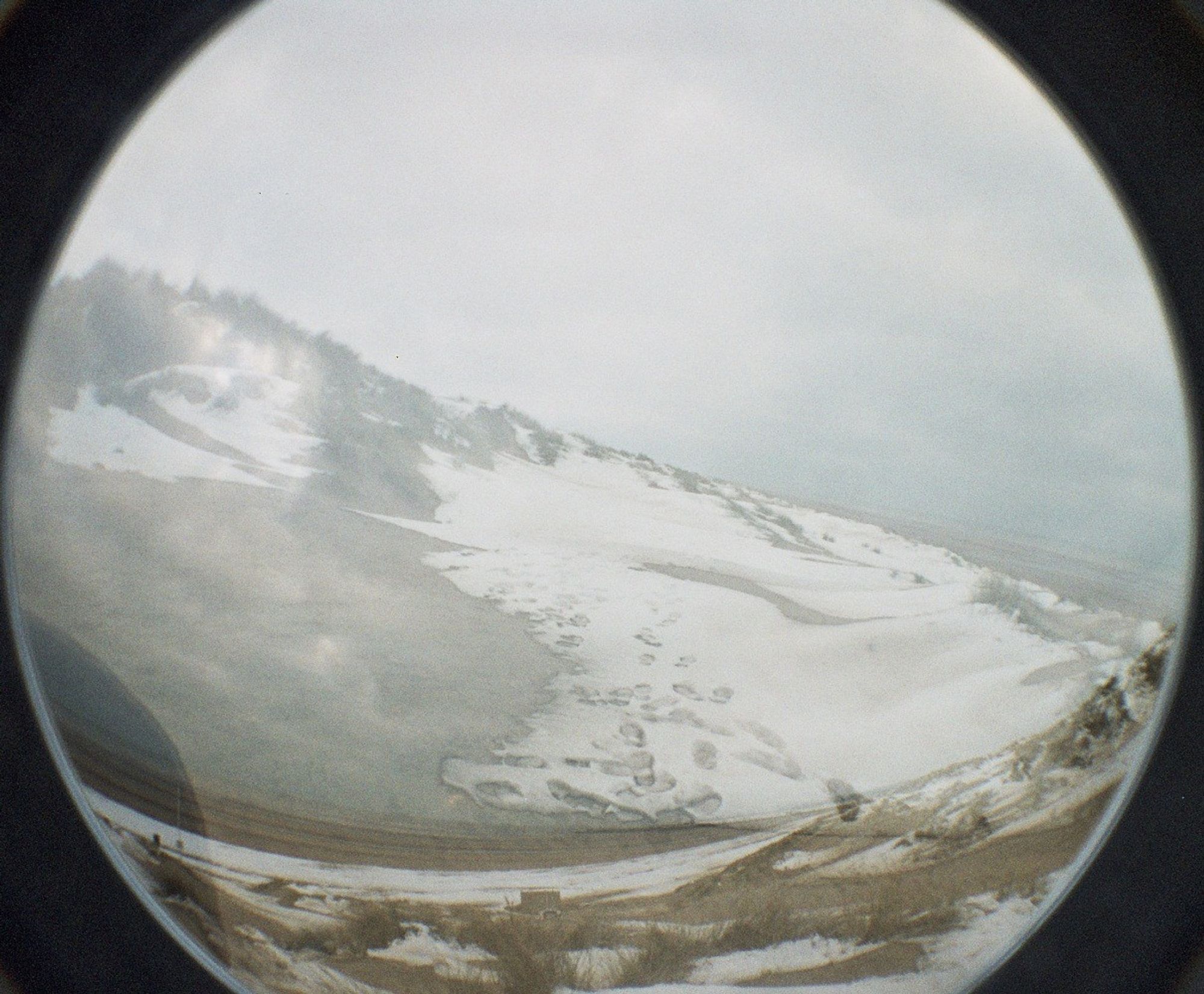 a double exposure fisheye photo of a snow covered beach