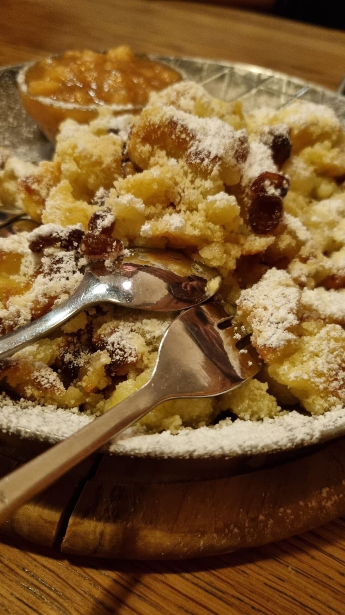 Eine kleine Pfanne mit Kaiserschmarrn, Puderzucker und Apfelkompott.