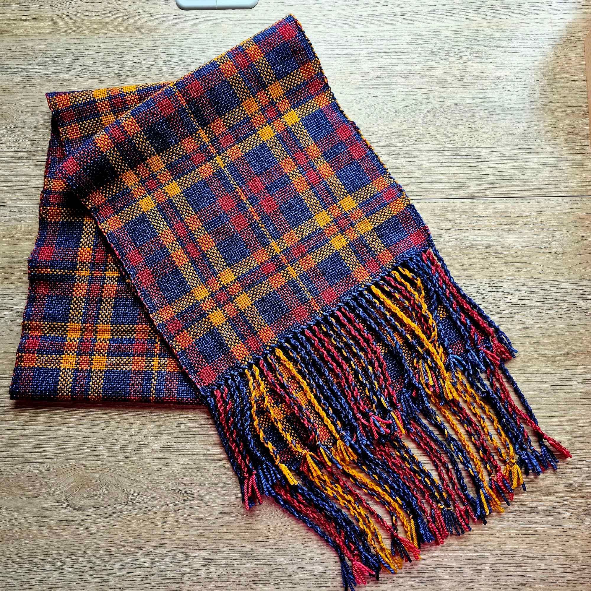 A navy, gold, and red plaid Merino scarf