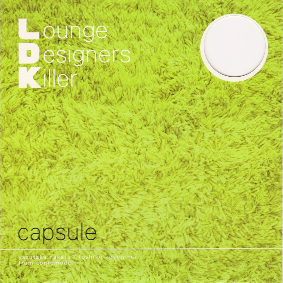 The cover art for Lounge Designers Killer by capsule. It is a close-up shot of a fluffy green rug with minimal text. There is a hole cut out in the upper corner. 