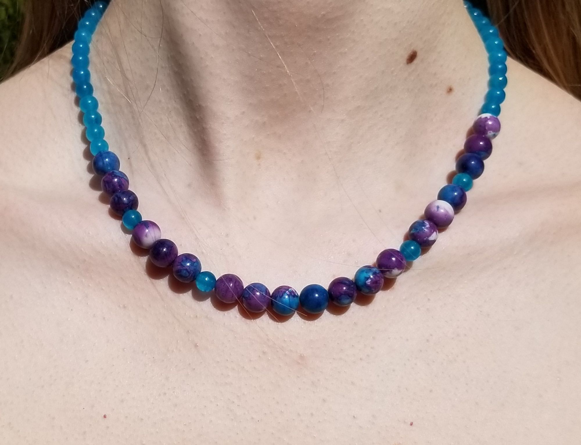 Necklace of rainstone and apatite, collar bone length, on a model.