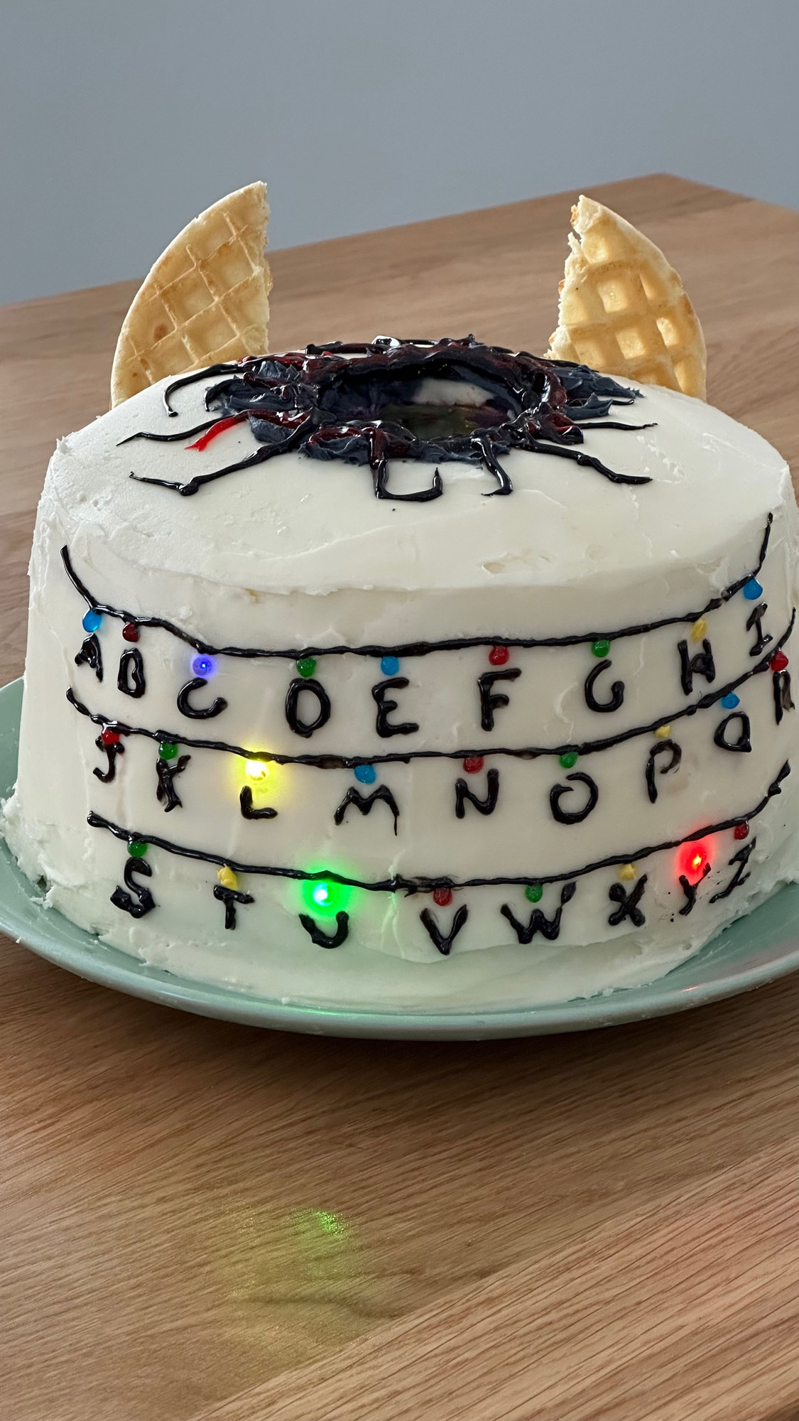 Stranger things birthday cake with string lights that spell out Lucy.