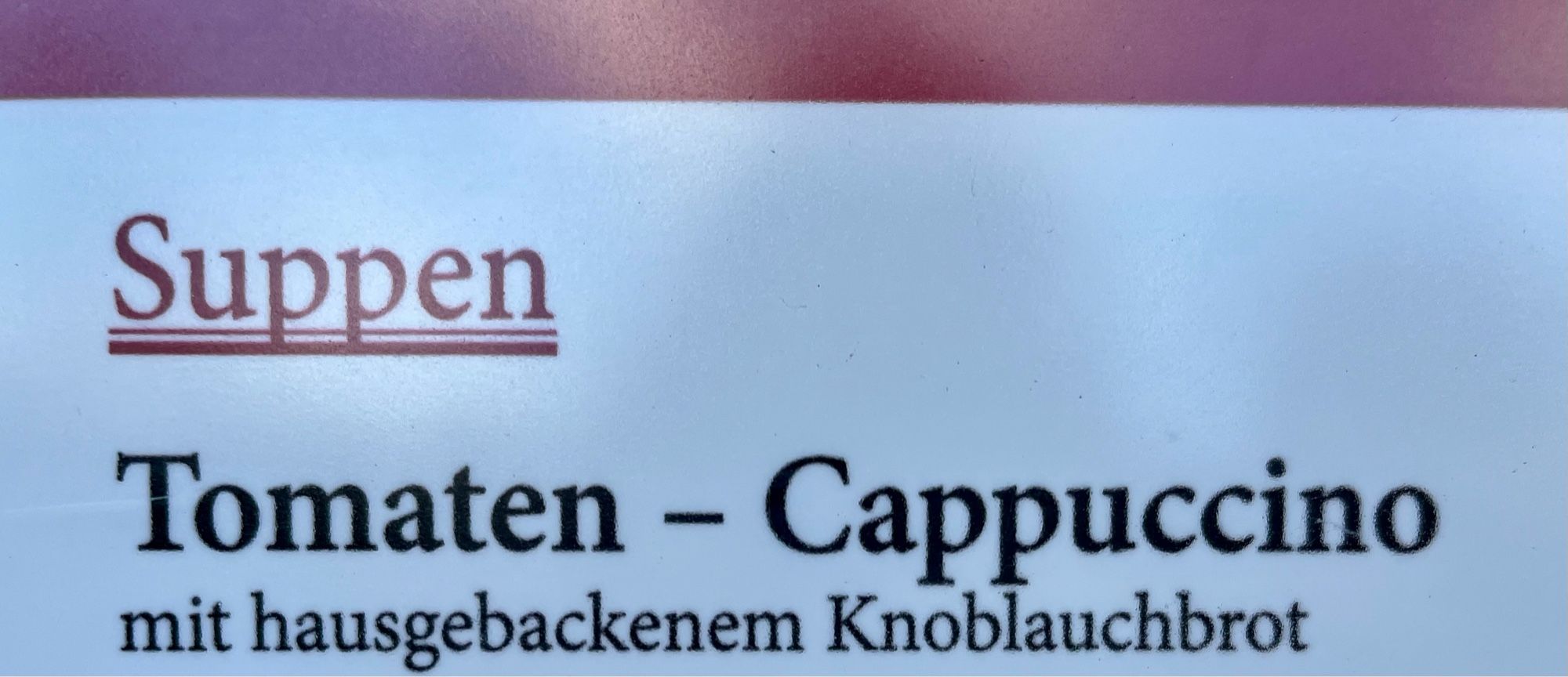 Speisekarte mit Tomaten-Cappuccin-Supe, dazu Knoblauchbrot. Und die große Frage Warum.