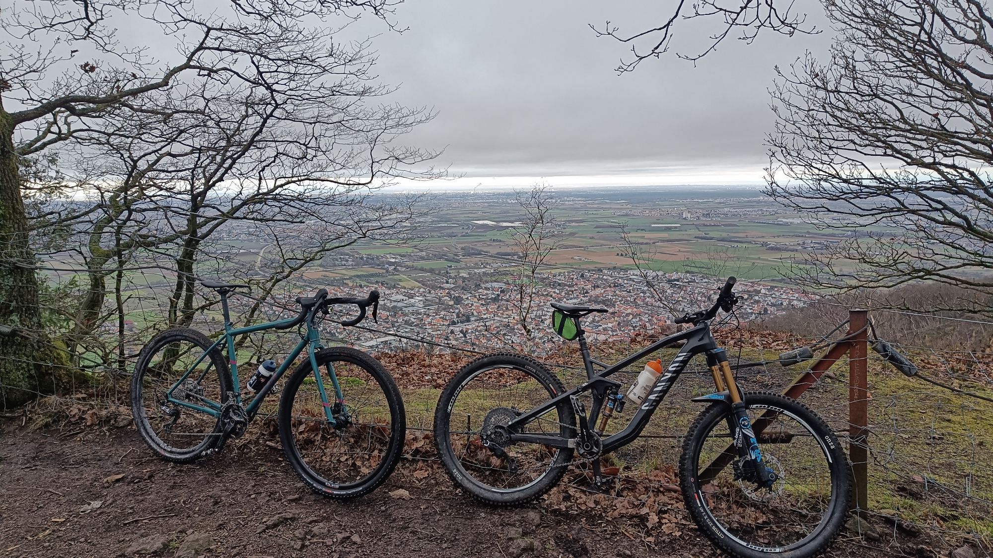 Ein Gravelbike und ein Fully auf einen Berg. Im Hintergrund Landschaft