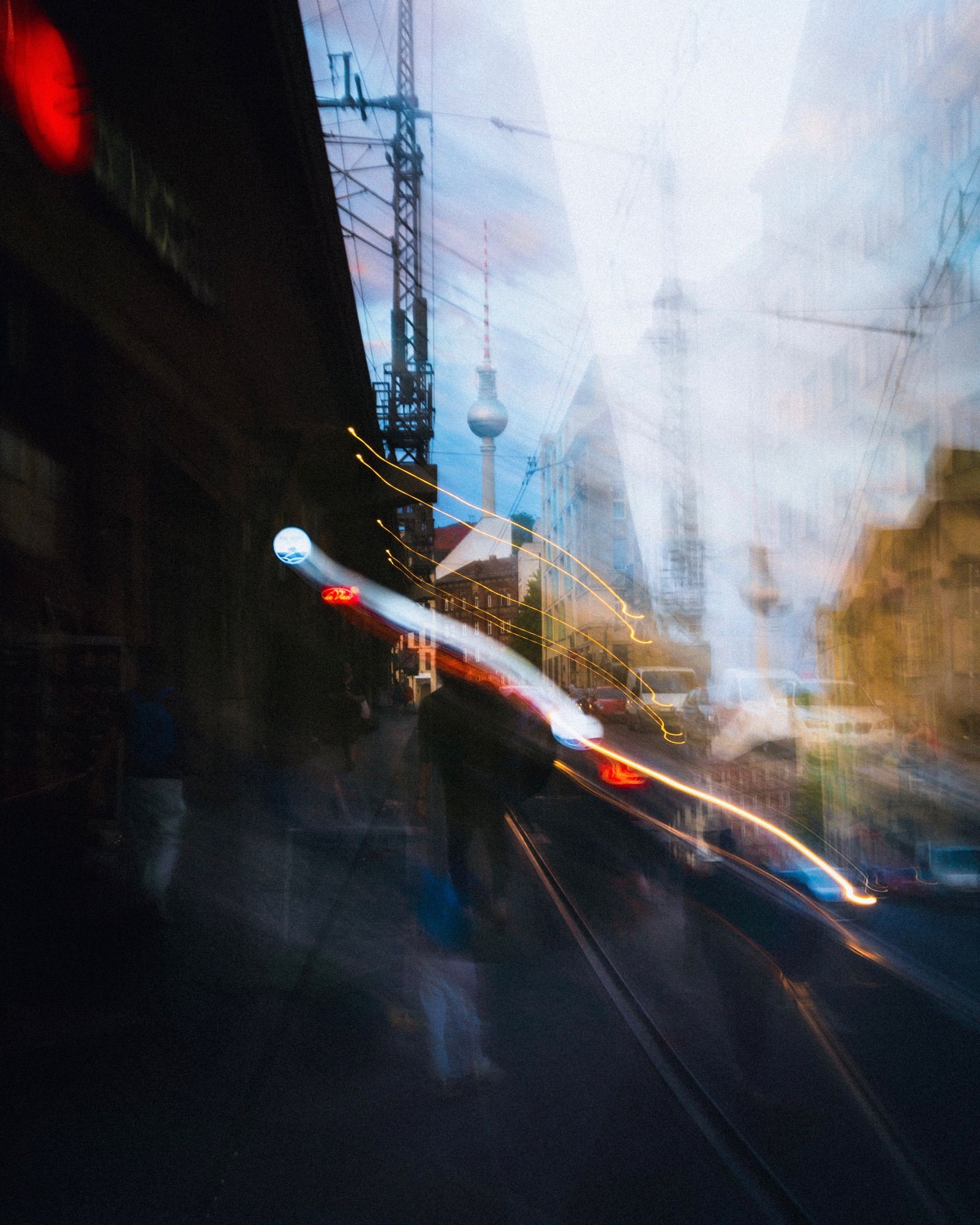 A photograph of a street in Mitte, Berlin, at daytime, and using long exposure to create 2 moments of the same scene overlapping with each other on one click. 