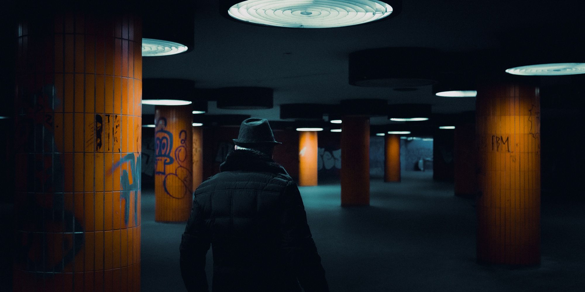 Man with a hat walking by an underground passage in Berlin, Germany.