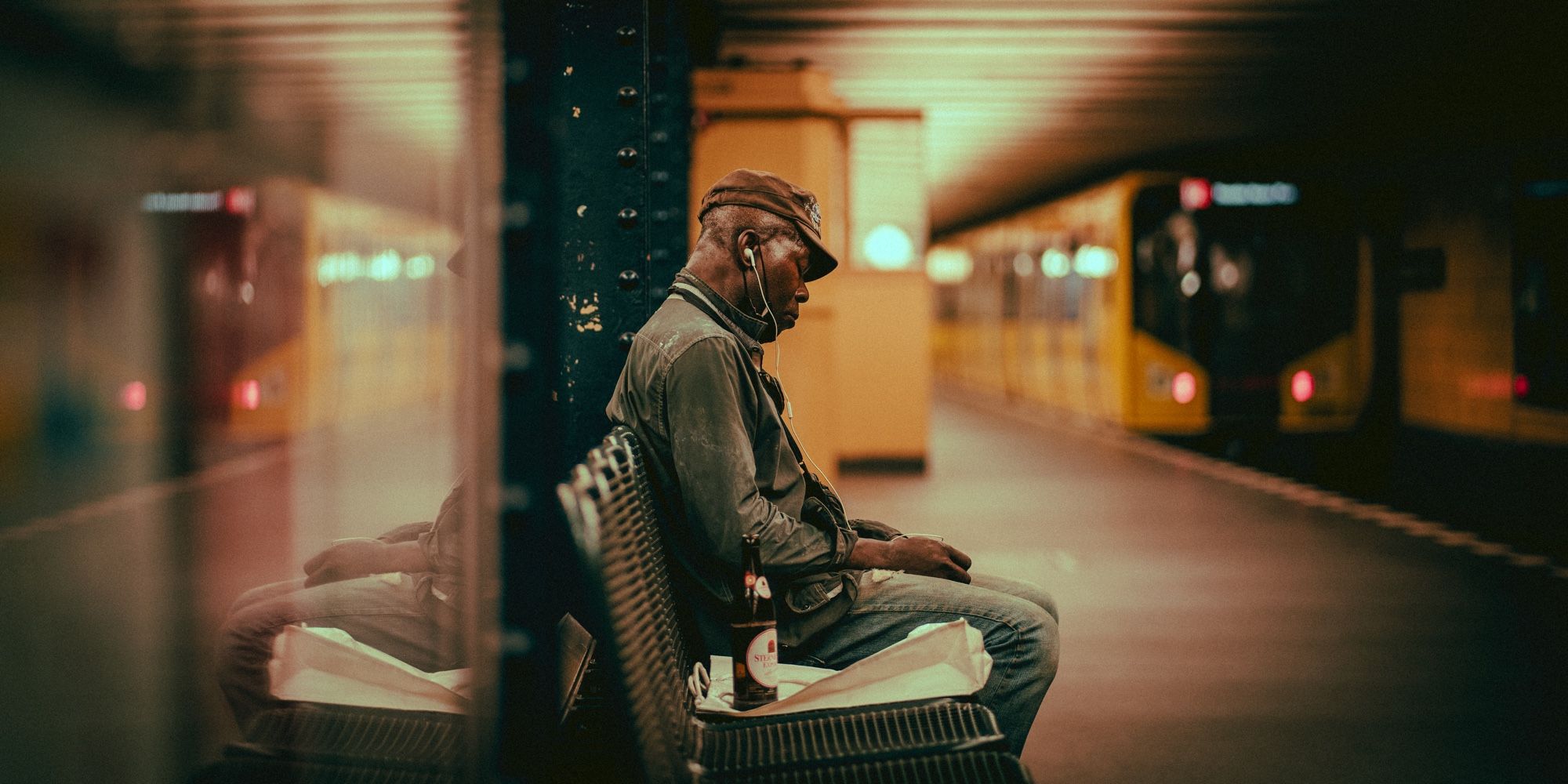 Man on a metro station’s platform in Berlin, listening to music while the train leaves the station.