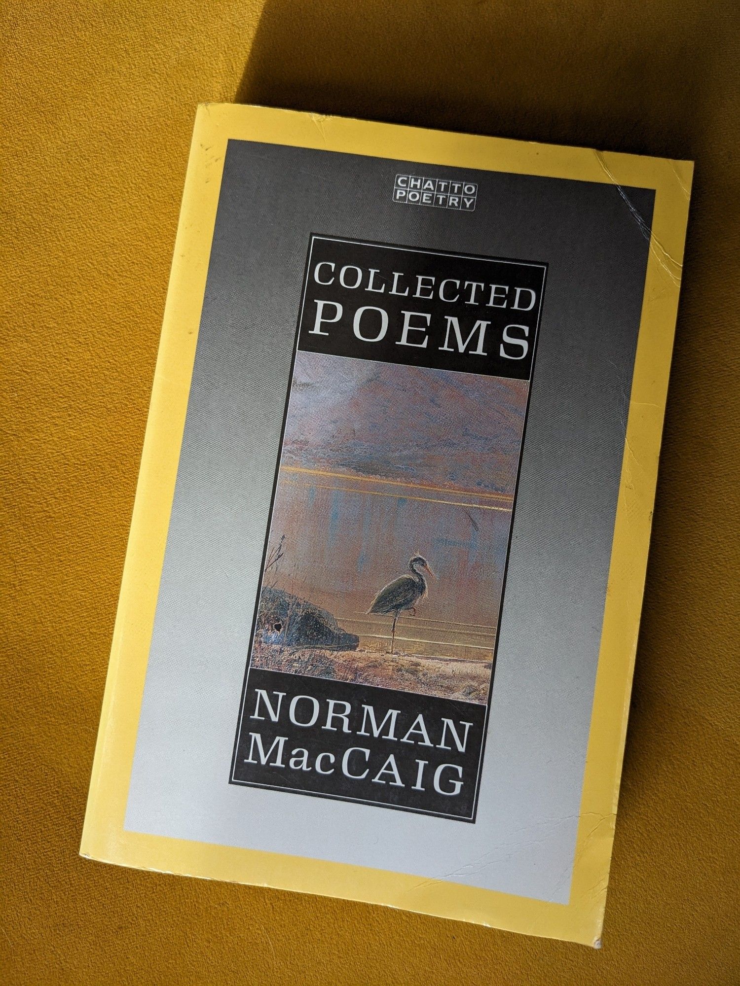 A copy of the 1988 Chatto and Windus paperback of Norman MacCaig's Collected Poems. The cover art is a detail from The Heron's Haunt by John Atkinson Grimshaw.