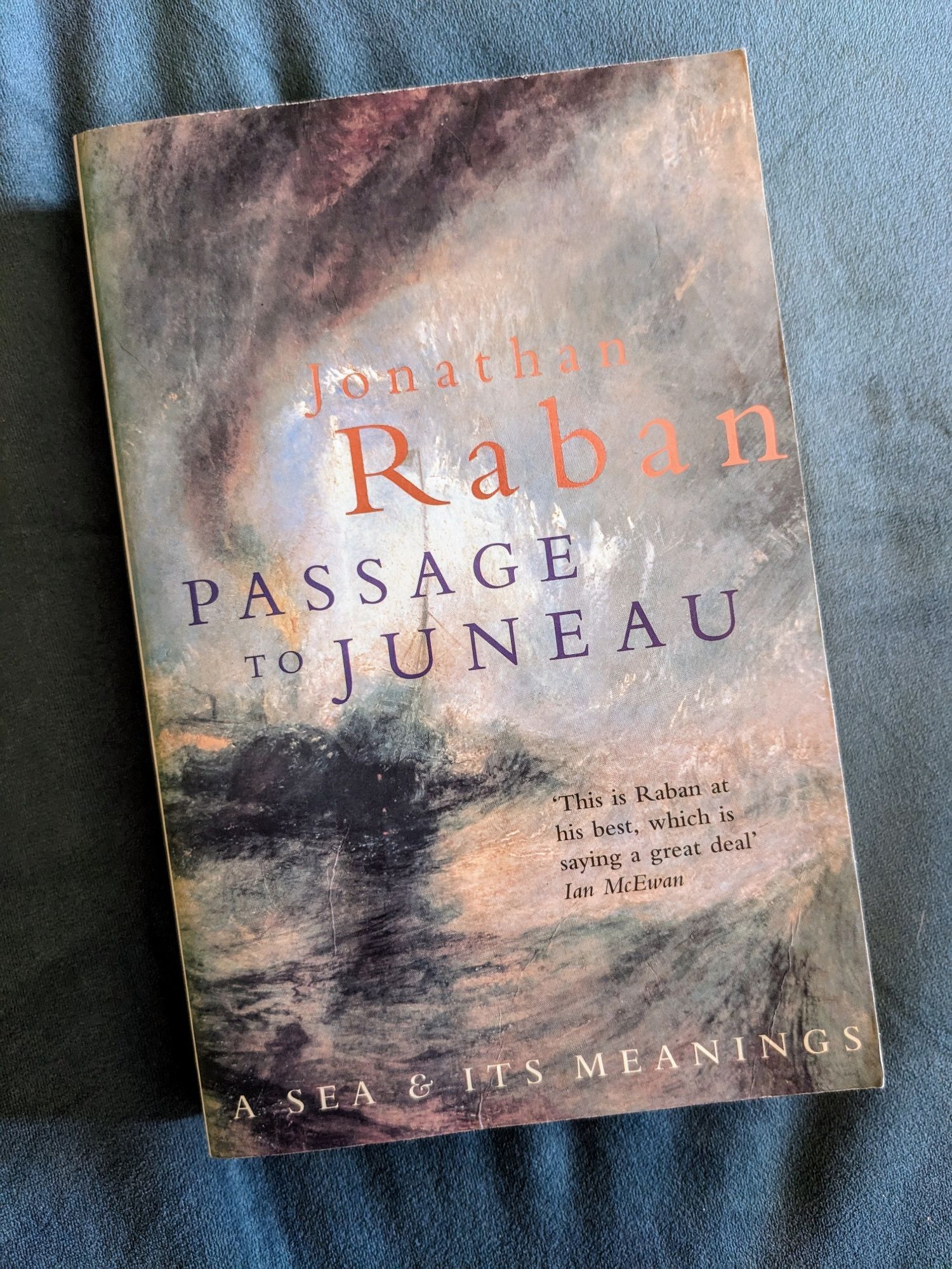 A copy of the 2000 Picador edition of Passage yo Juneau by Jonathan Raban. The cover uses a detail from the paining "Snow Storm - Steam Boat off a Harbour's Mouth" by J.M.W. Turner.