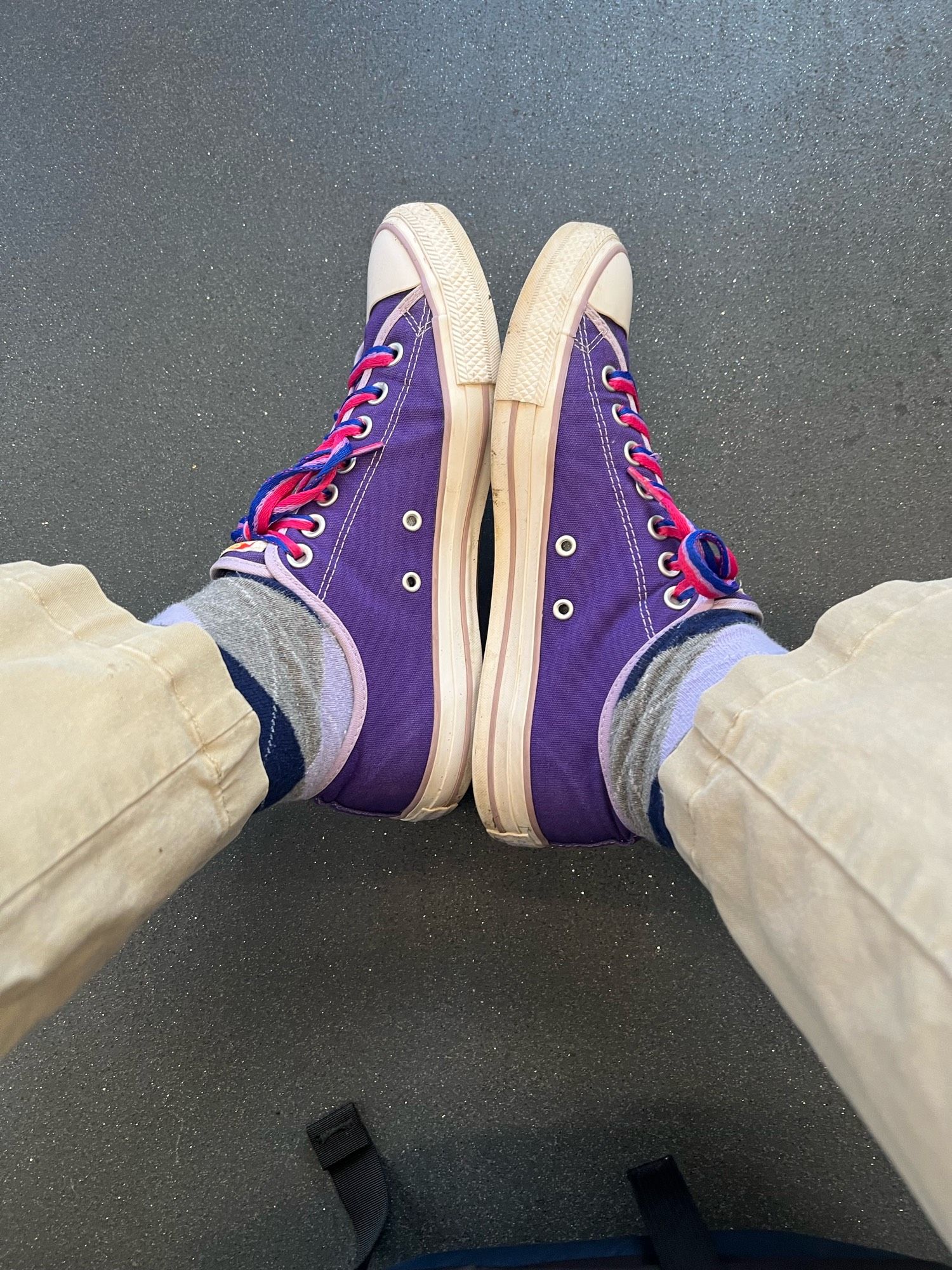 Purple and lavender Chuck Taylor low-top shoes with laces in the color of the Bisexual Pride flag.