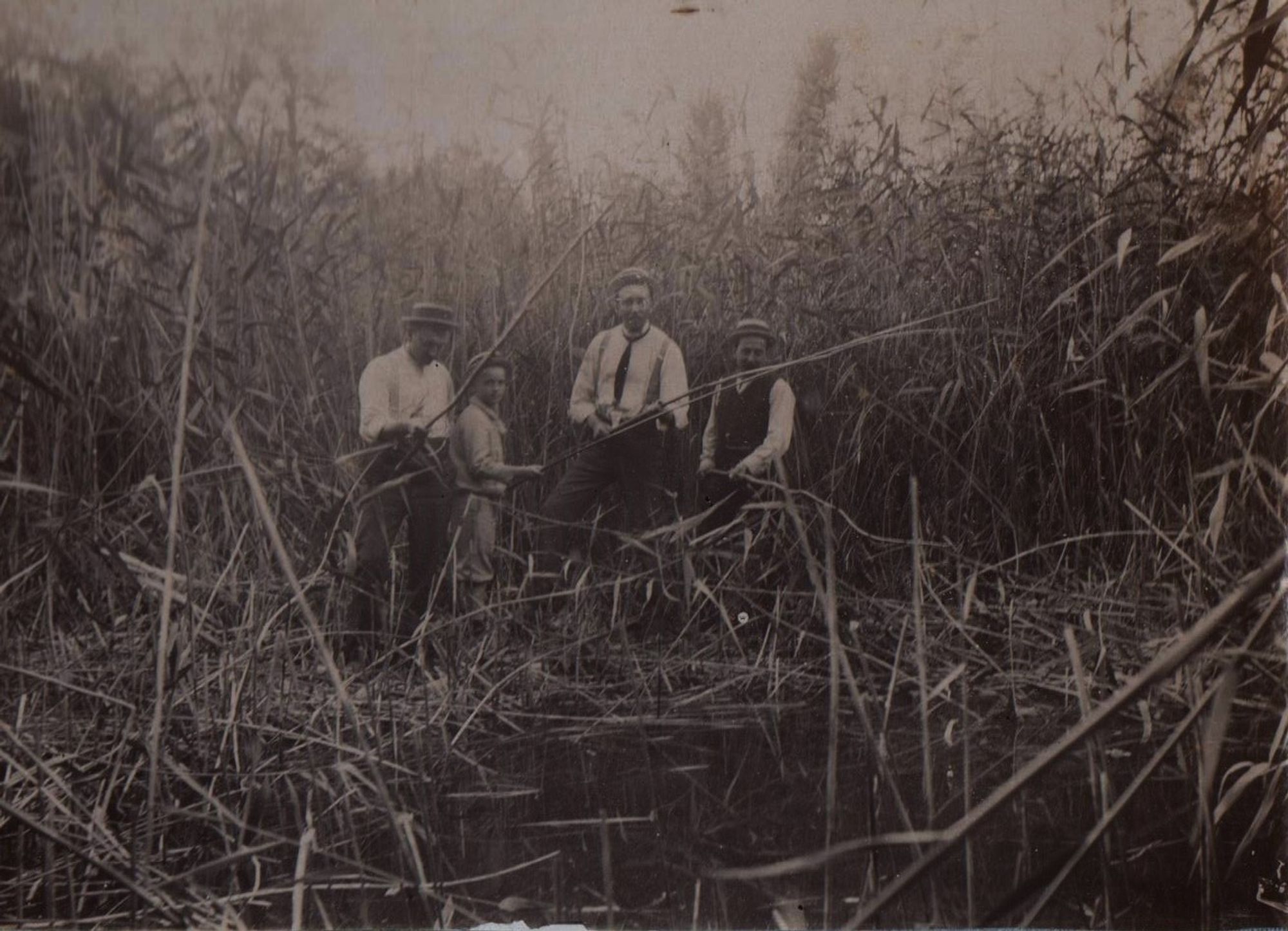 vieille photo du début du 20 ème siècle, mon grand père et 3 autres personnes pêchent dans les roseaux.