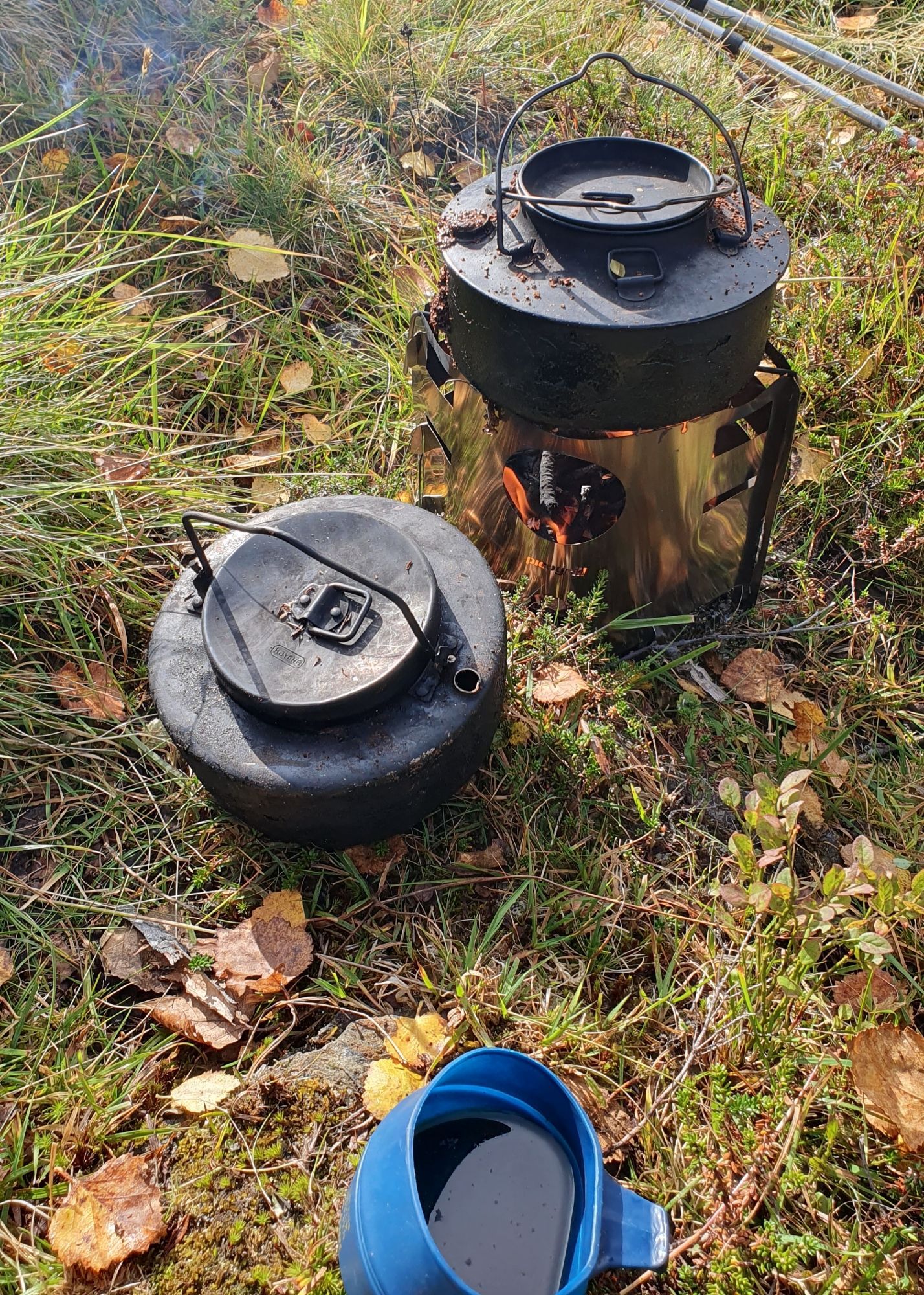 Forfra: På østlig skogbunn ferdig kaffe i "snyltekopp", svartkjel trolig med ferdig kaffe og svartkjel på kvistbrenner.