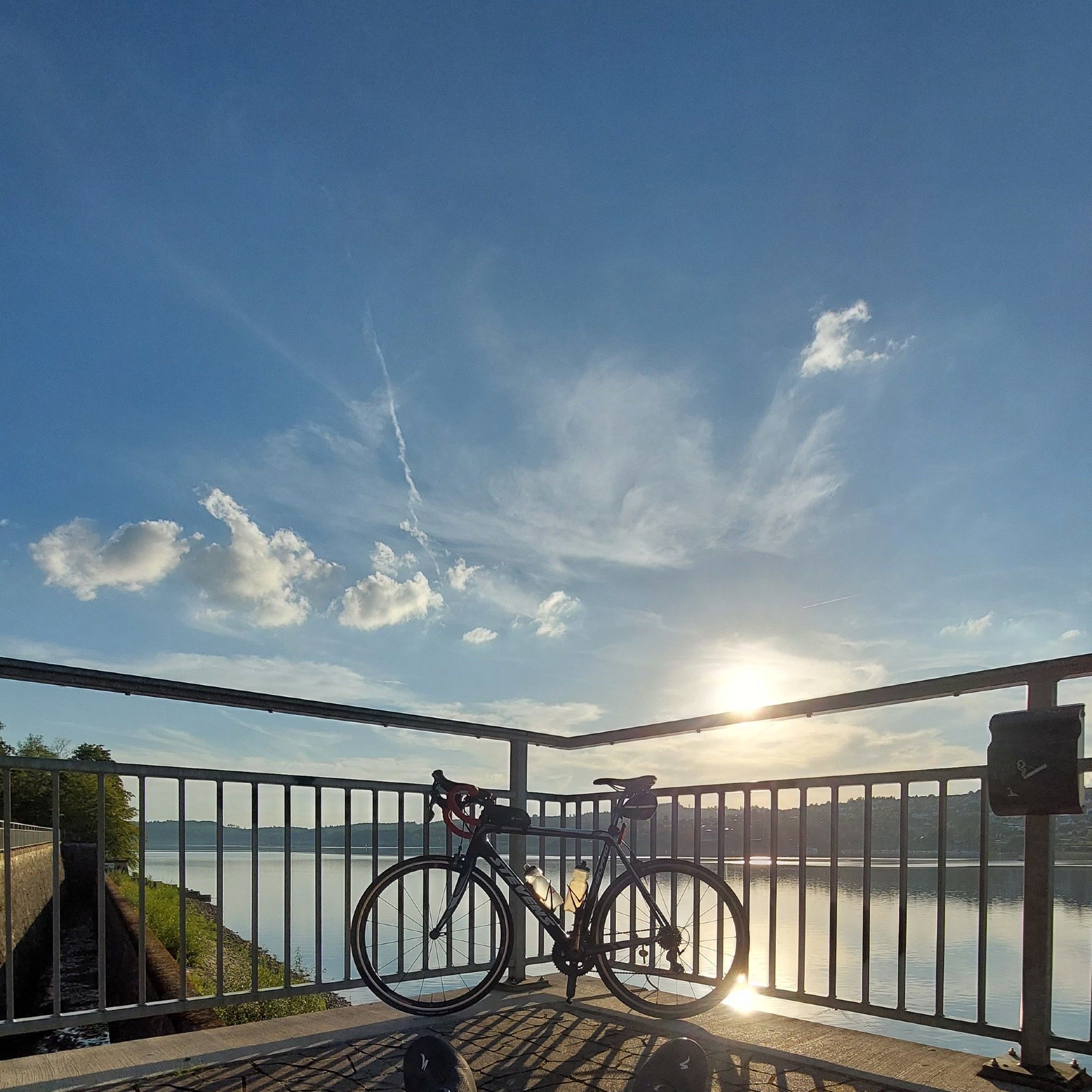 Rennrad vor blauem Himmel bei niedrigstehender Sonne