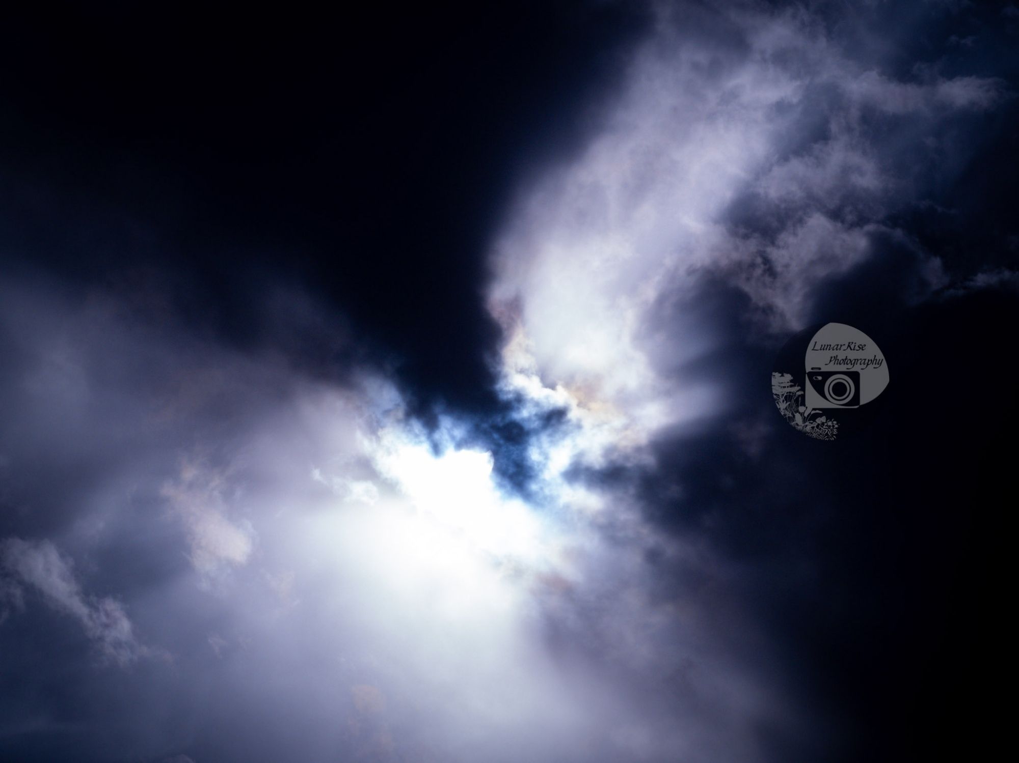 dark clouds filled with light from the solar eclipse, which is not visible