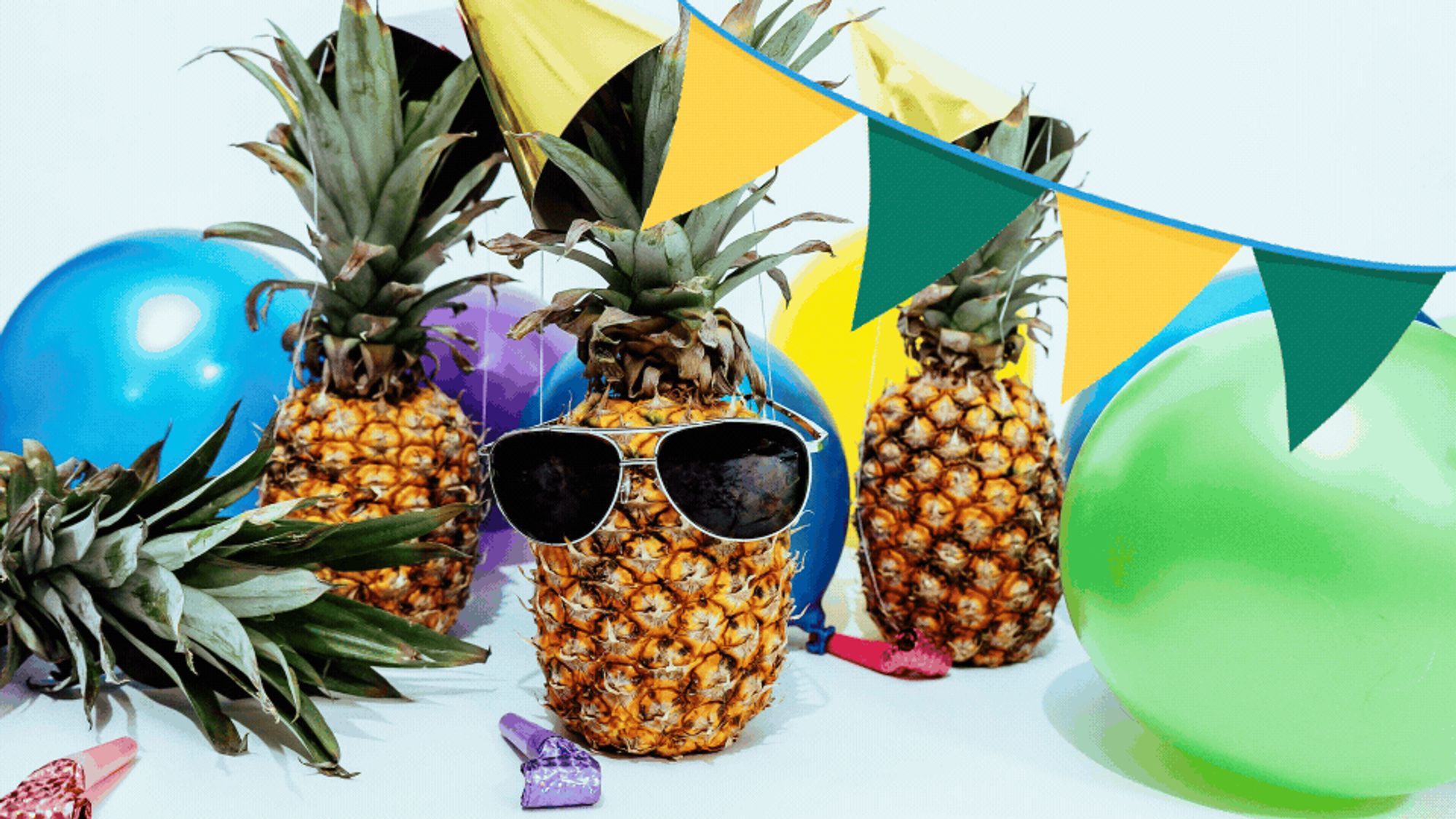 pineapples partying with balloons and hats. a pineapple wearing sunglasses is looking at you.