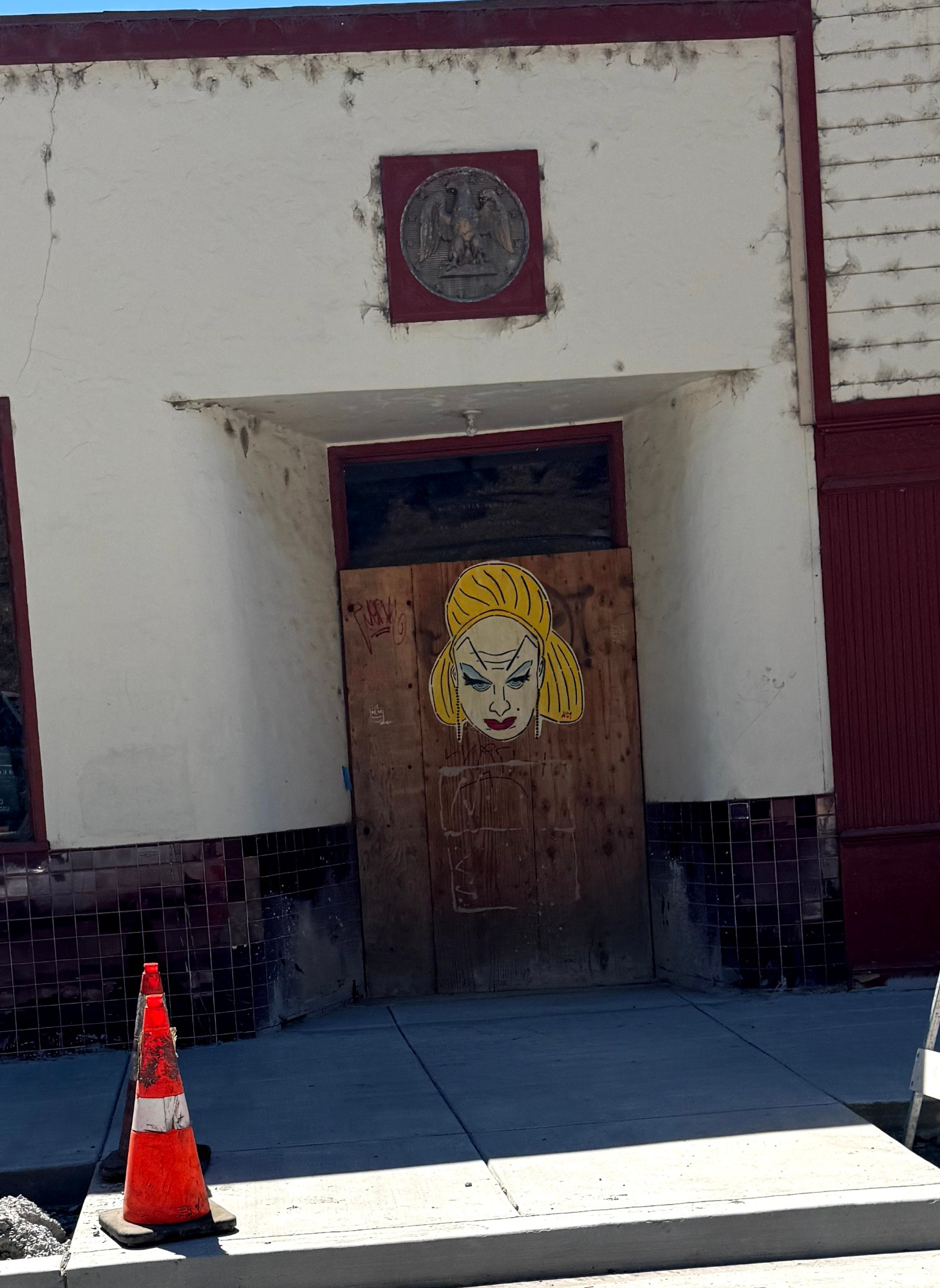 A pasteup of Divine on a boarded up door in Guerneville, CA