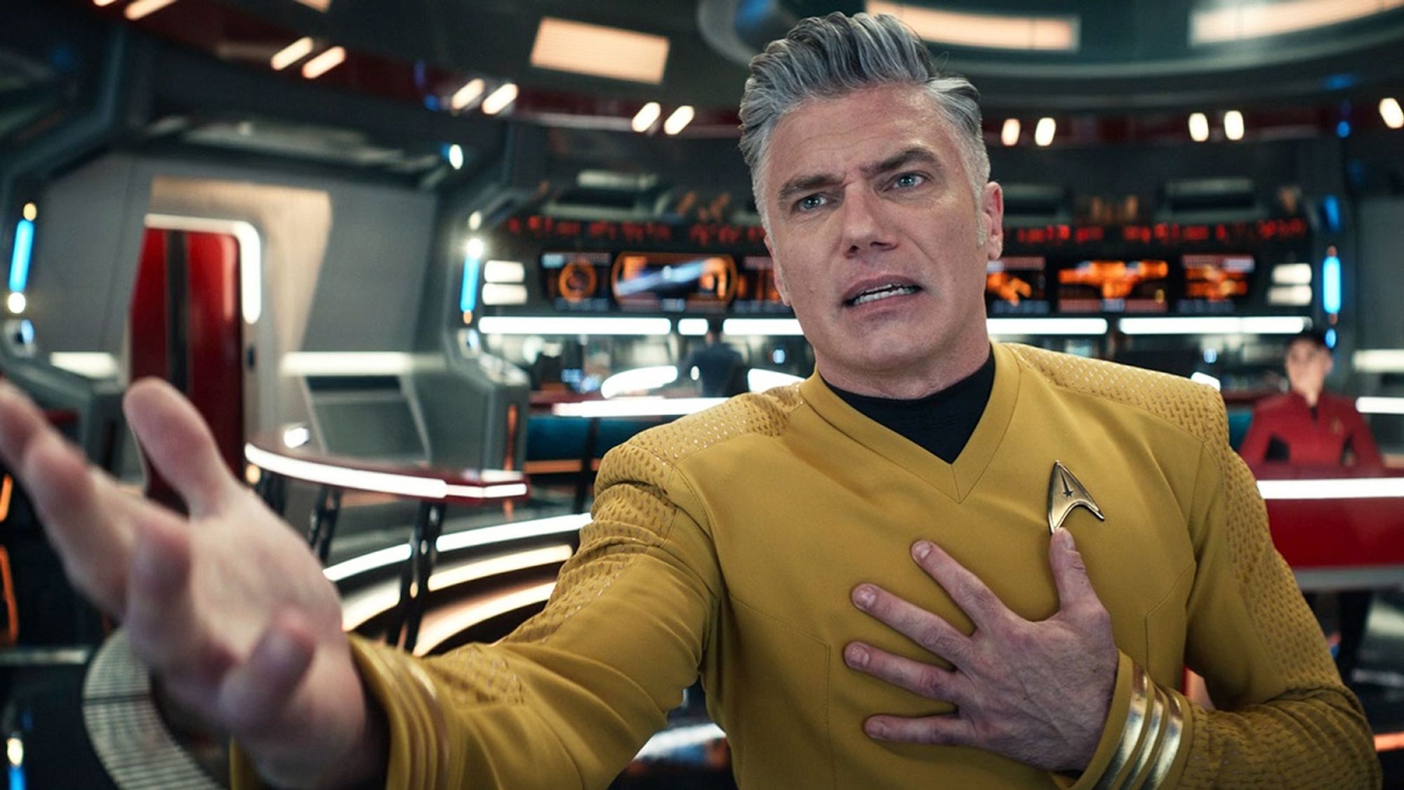 Captain Pike looking distressed while reaching out towards the bottom corner of the camera with an upturned open right hand and his left hand on his chest as if "to beseech you." He is being OVERLY dramatic here.