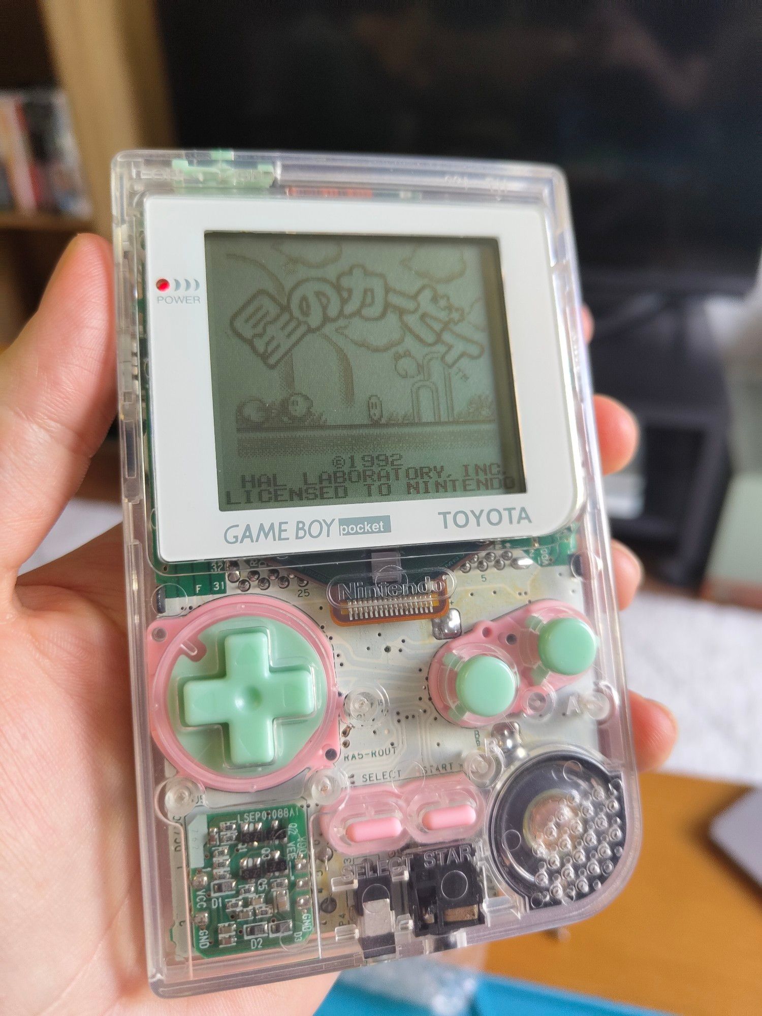 Gameboy pocket with clear shell, pink rubber pads, seafoam green buttons, white lens, and original LCD