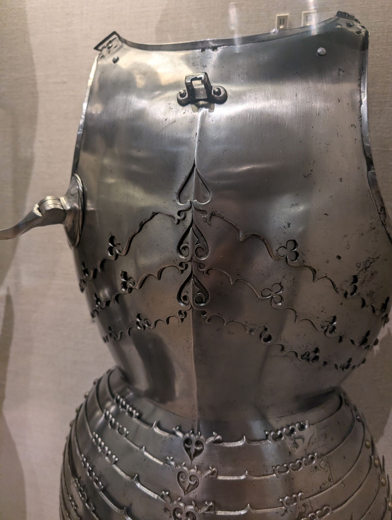 A closeup view of an ornate cuirass and tasset, showing heart-shaped designs along the edges of the metal panels.