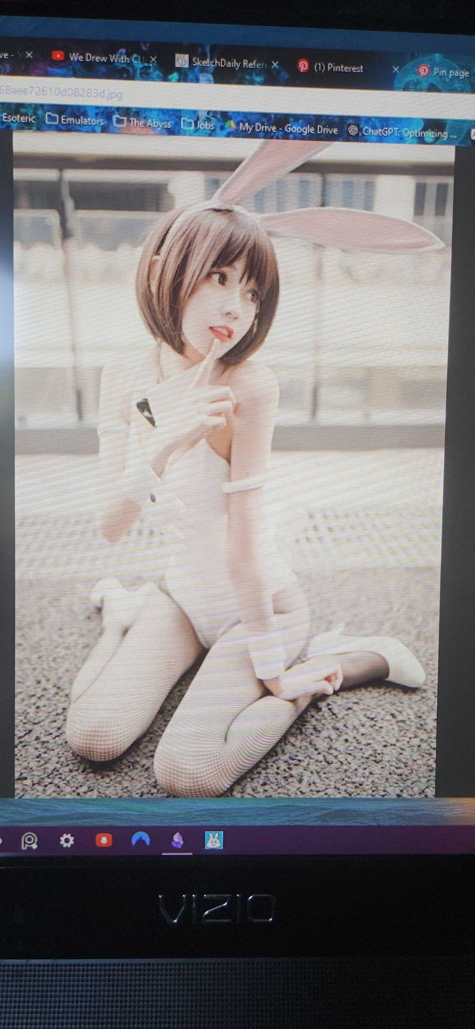 A picture of a bunny girl sitting on the ground. Her right index finger is to her lip in a shushing gesture.