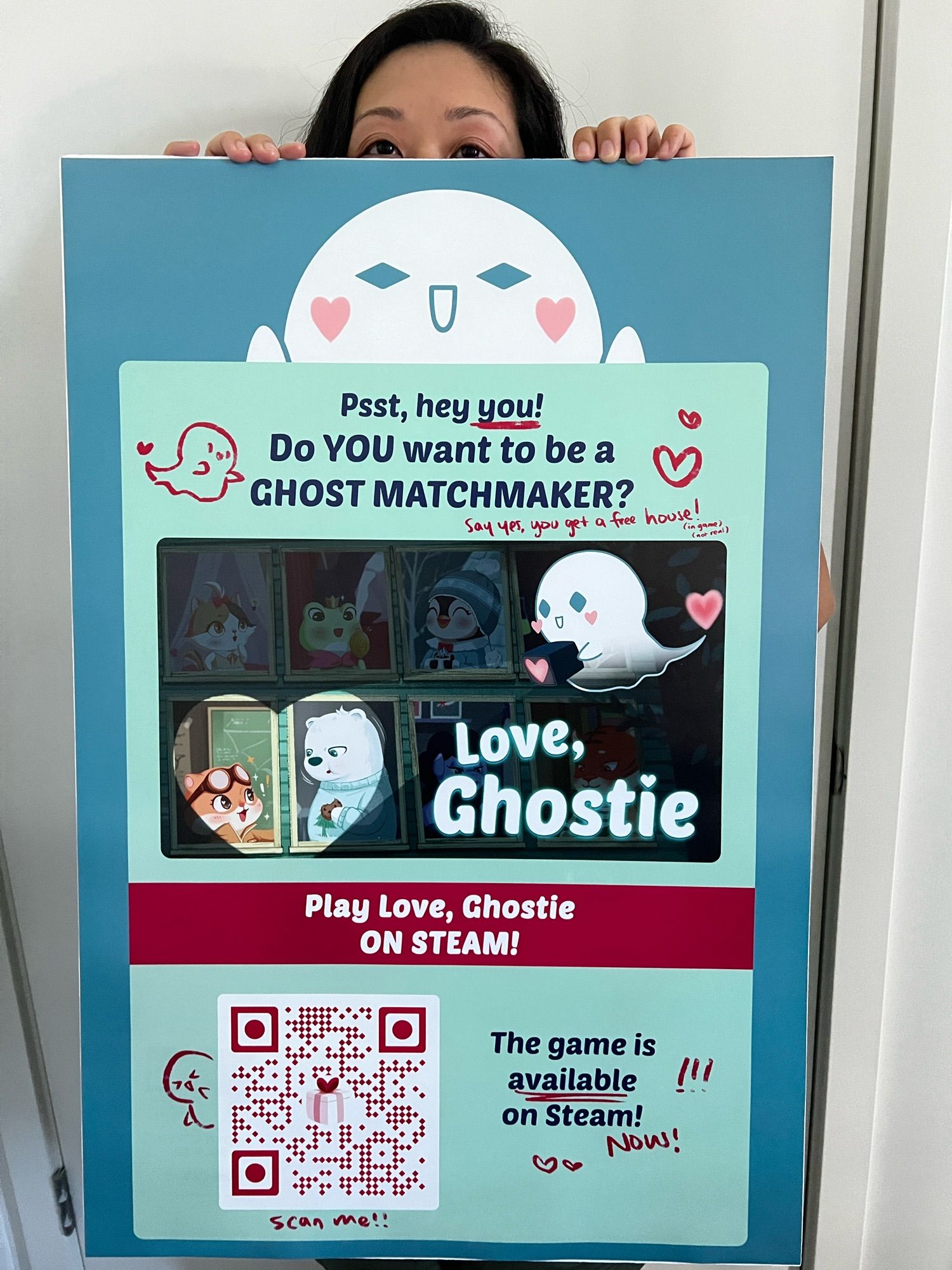 Me holding a big poster of Love, Ghostie that has a QR code and description of the game