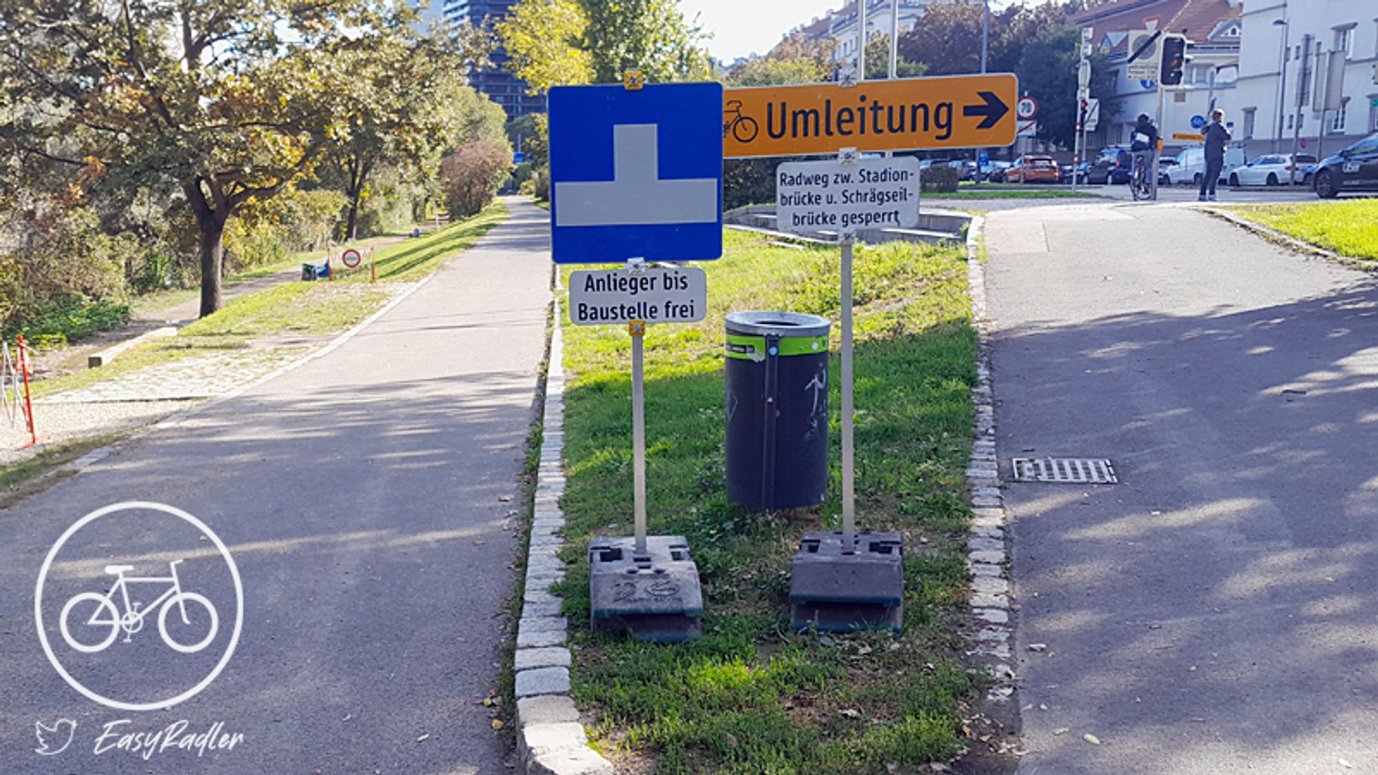 Bildbeschreibung: Verkehrsschilder weisen kurz vor der Stadionbrücke auf eine Sperre der Promenade am Donaukanal und eine Umleitung für Radfahrer hin.