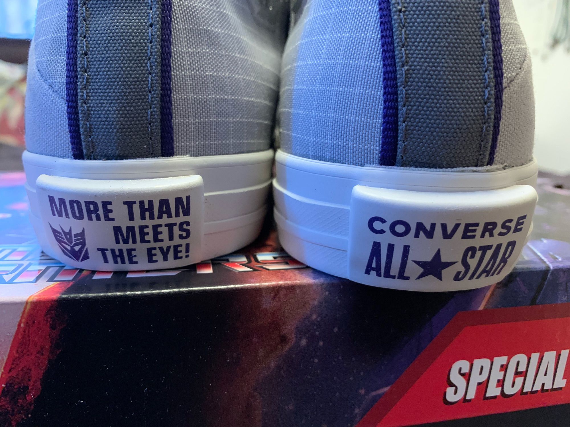 The heel of Converse Megatron grey hi-top sneakers, it says “More Than Meets The Eye”