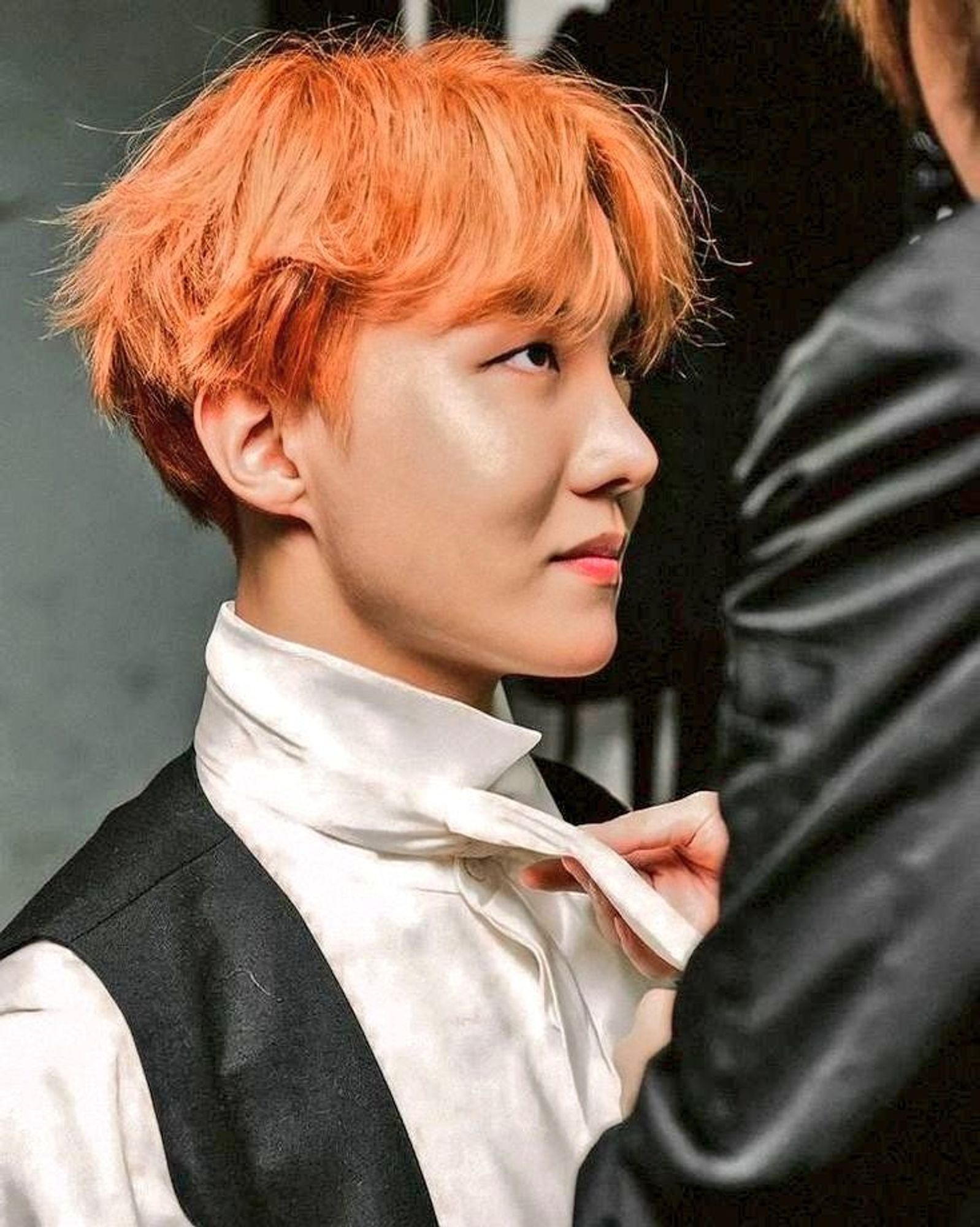 Orange haired Hobi having his tie tied