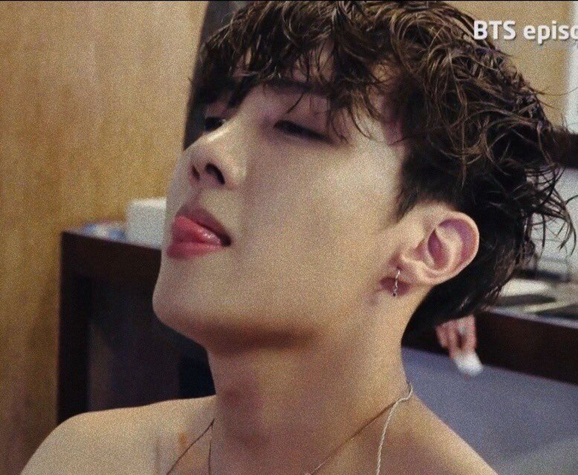 Close up of a shirtless Hobi, with his tongue out