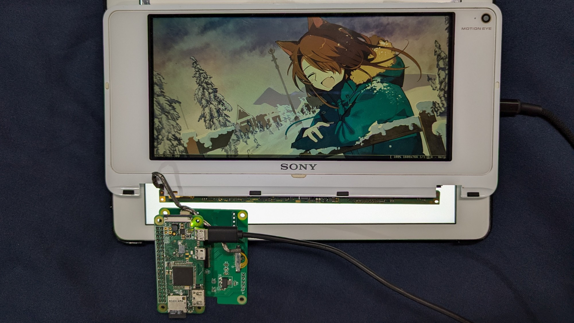 One of the pieces of "Project Koyomi", a Raspberry Pi hat to allow the use of Sony Vaio P displays, temporarily backlit by a tablet with a white image on.