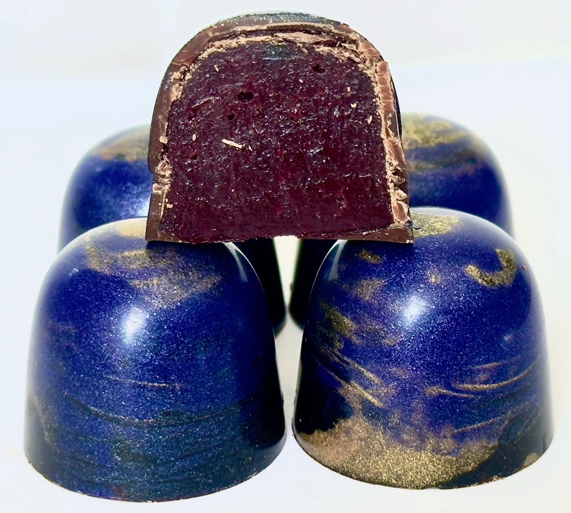 A few blue and gold chocolate bonbons filled with blackcurrent caramel.