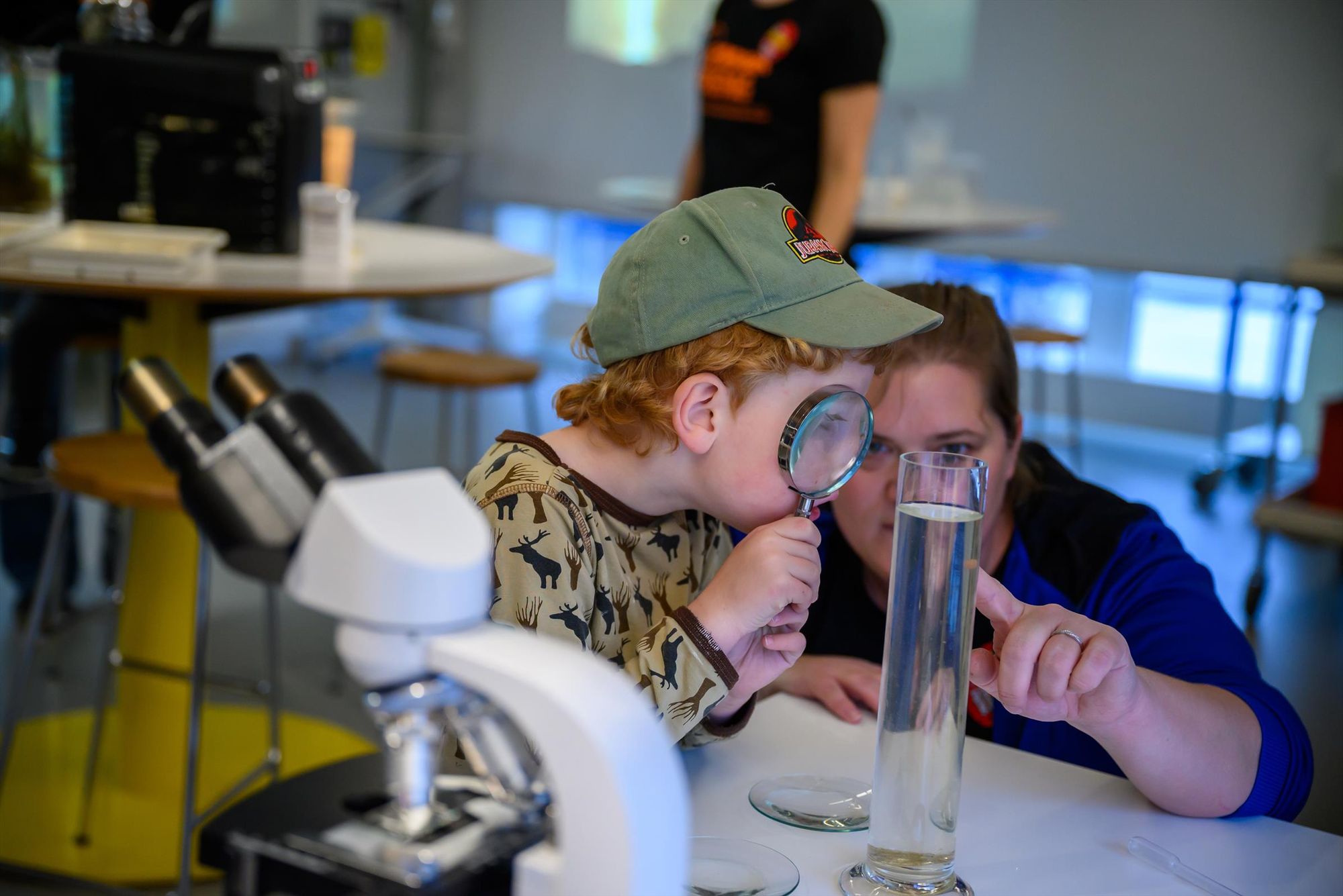 A child uses a magnifying glass to find out what is in the water during the European Researchers' Night at Umeå University. Photo: Gabrielle Beans Picón