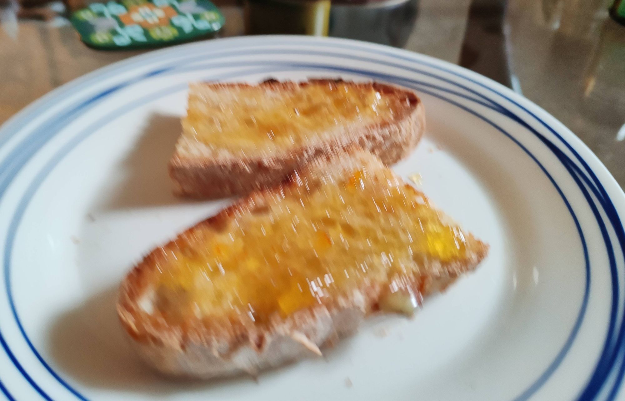 Two rustic-looking slices of toasted white bread and marmalade