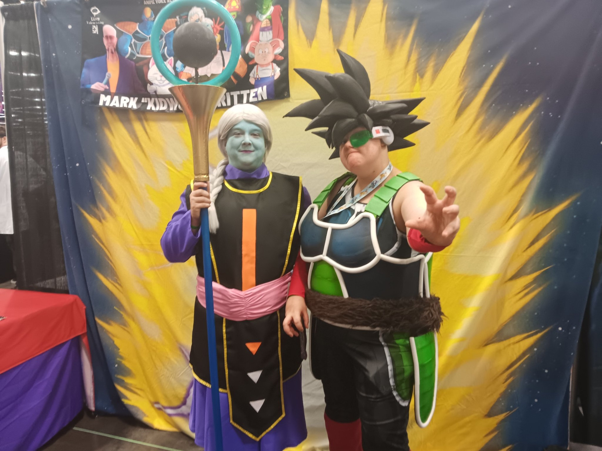 Michea cosplaying as Kusu from Dragon Ball Super next to their kid who is cosplaying as Bardock.