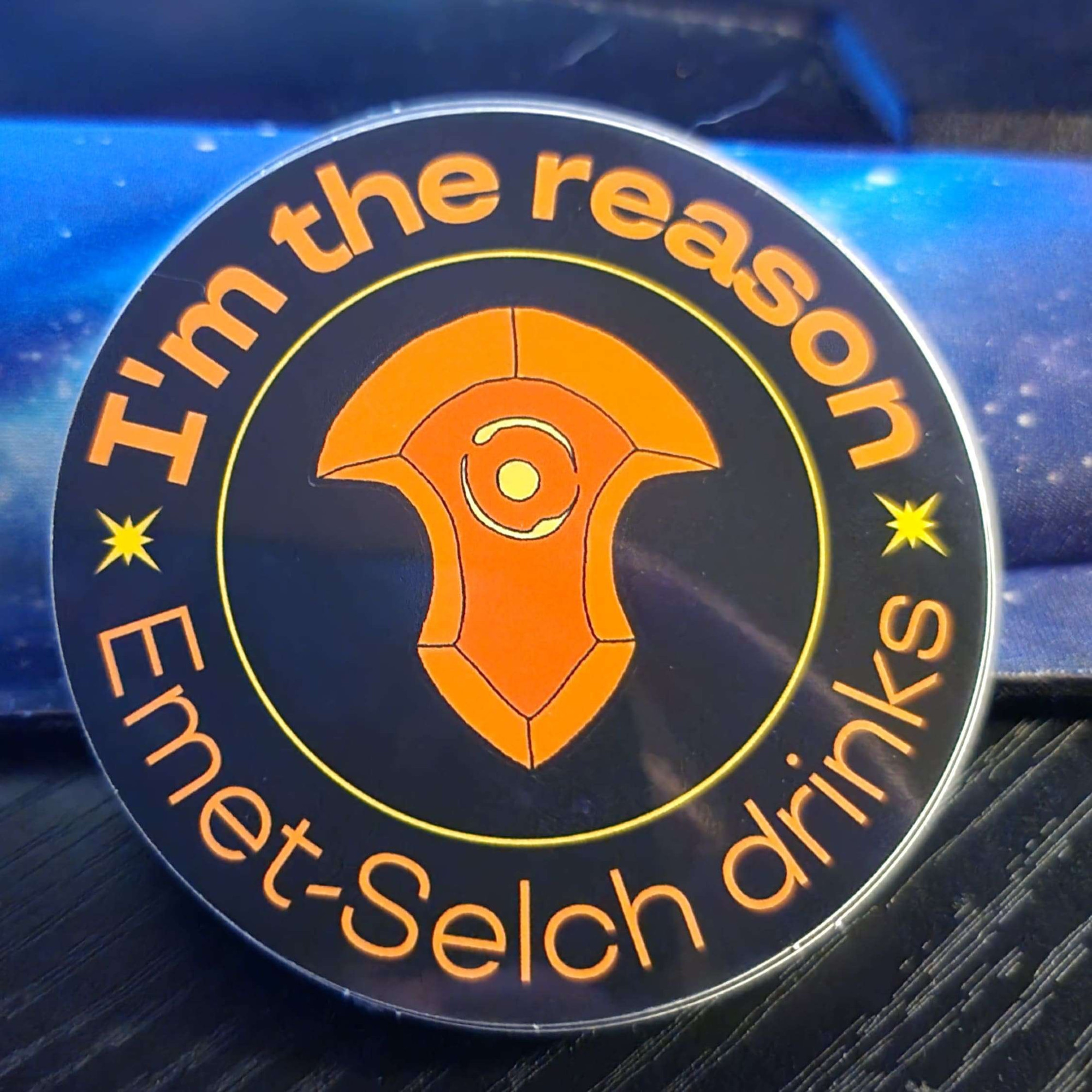 A sticker with the Azem convocation stone from FFXIV in the center with text reading, "I'm the reason Emet-Selch drinks" around the border.