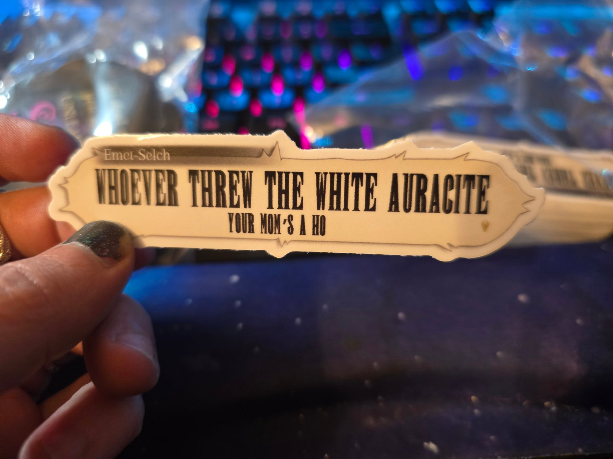 A sticker reading, "Whoever threw the white auracite your mom's a ho" in the shape of a text box from FFXIV