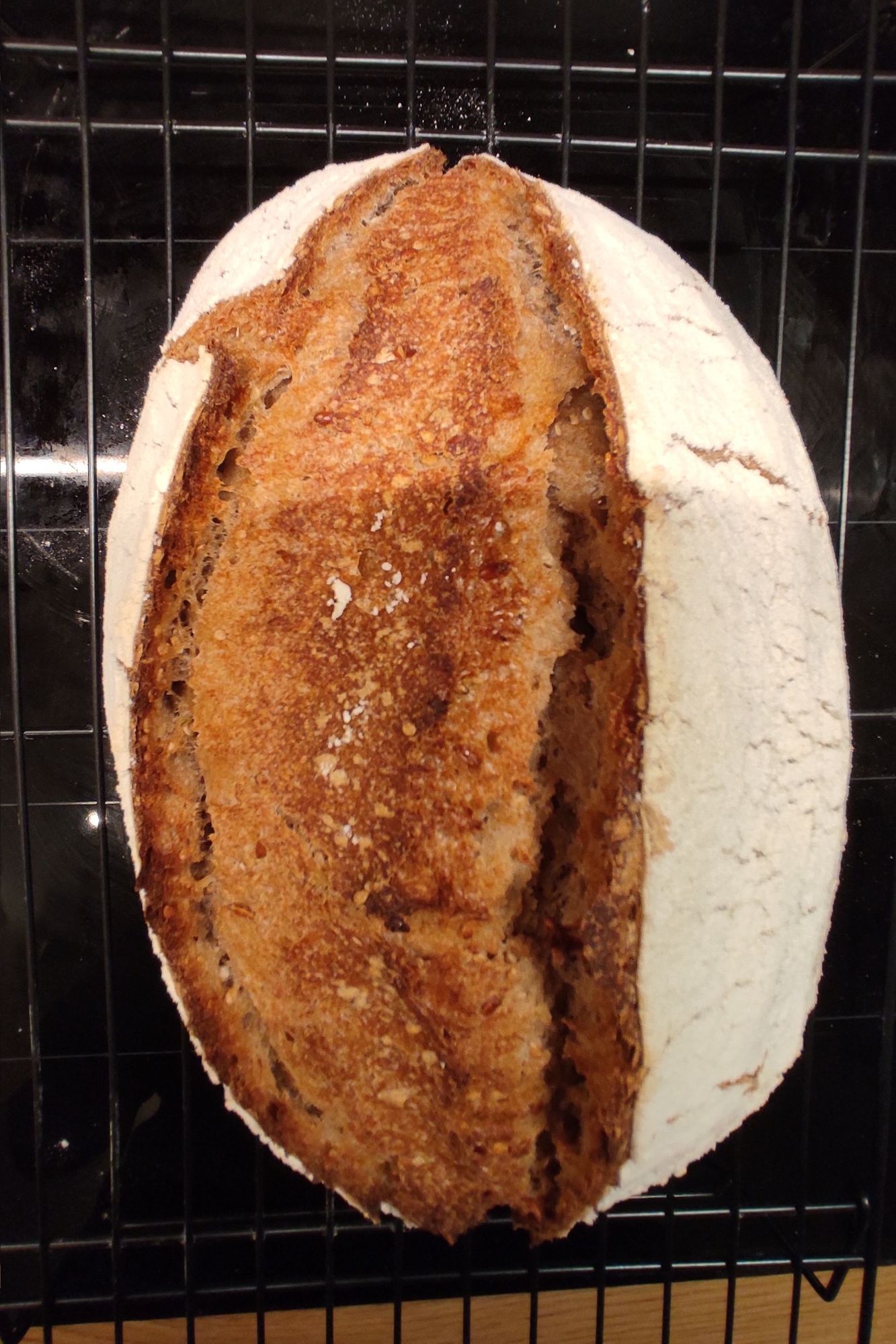 A loaf of sourdough bread cooling on a rack