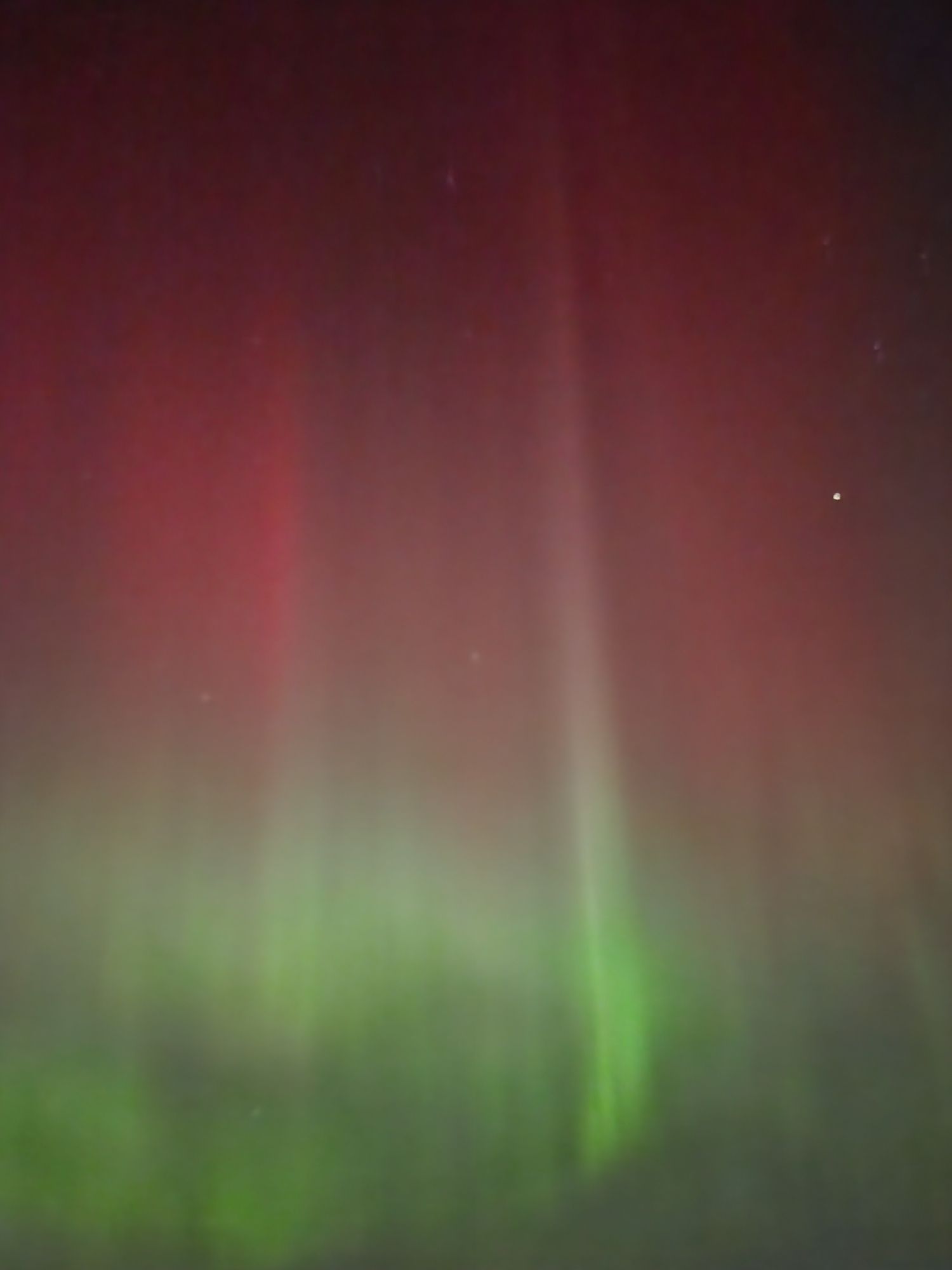 Northern lights with bright vertical stripes, red over bright green.