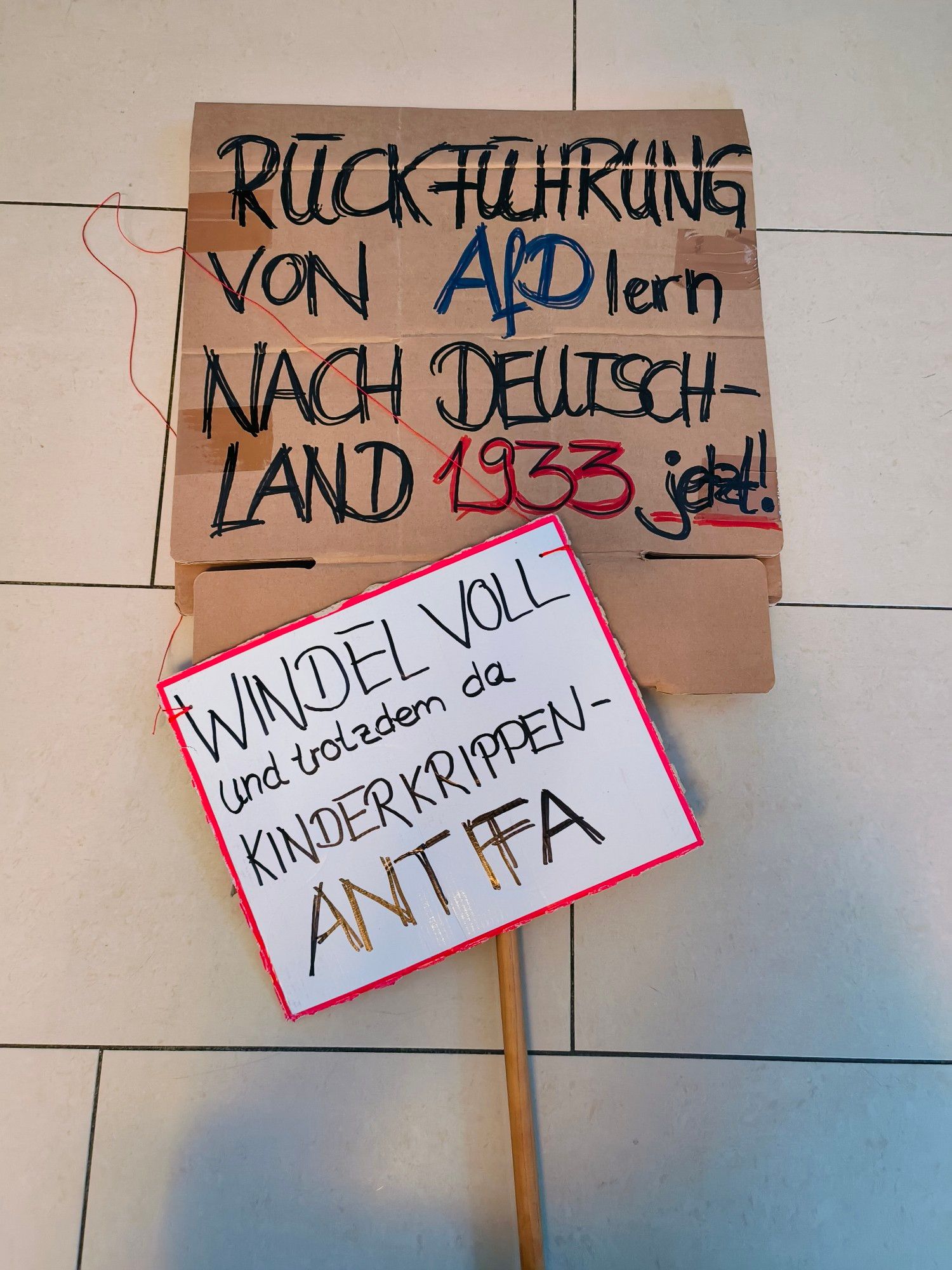 Großes Demoschild: 
Rückführung von AfDlern nach Deutschland 1933 jetzt!

Kleines Umhängeschild:
Windel voll und trotzdem da, Kinderkrippen-Antifa